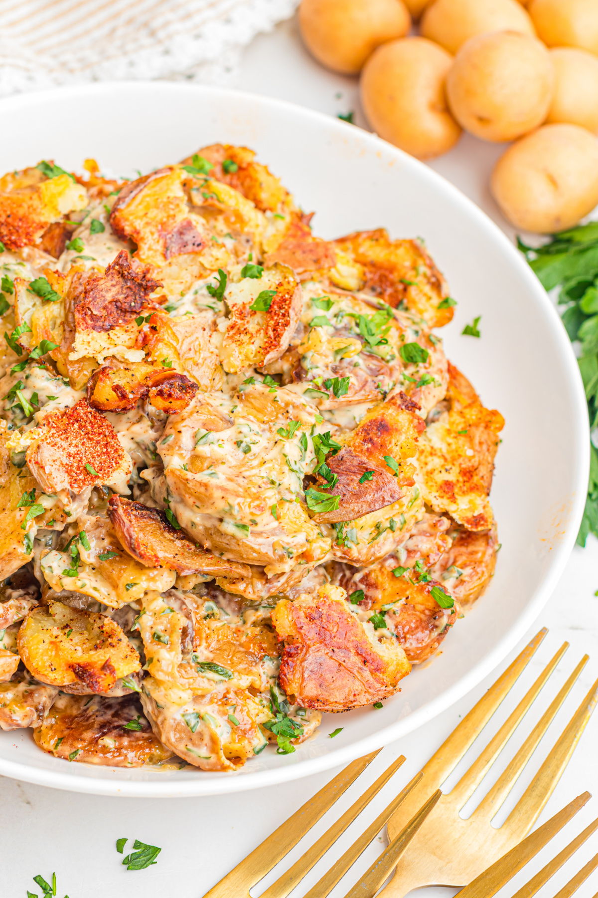 Crispy Smashed Potato Salad with roasted smashed baby potatoes, creamy lemon herb dressing, fresh dill, and crispy golden edges in a white serving bowl