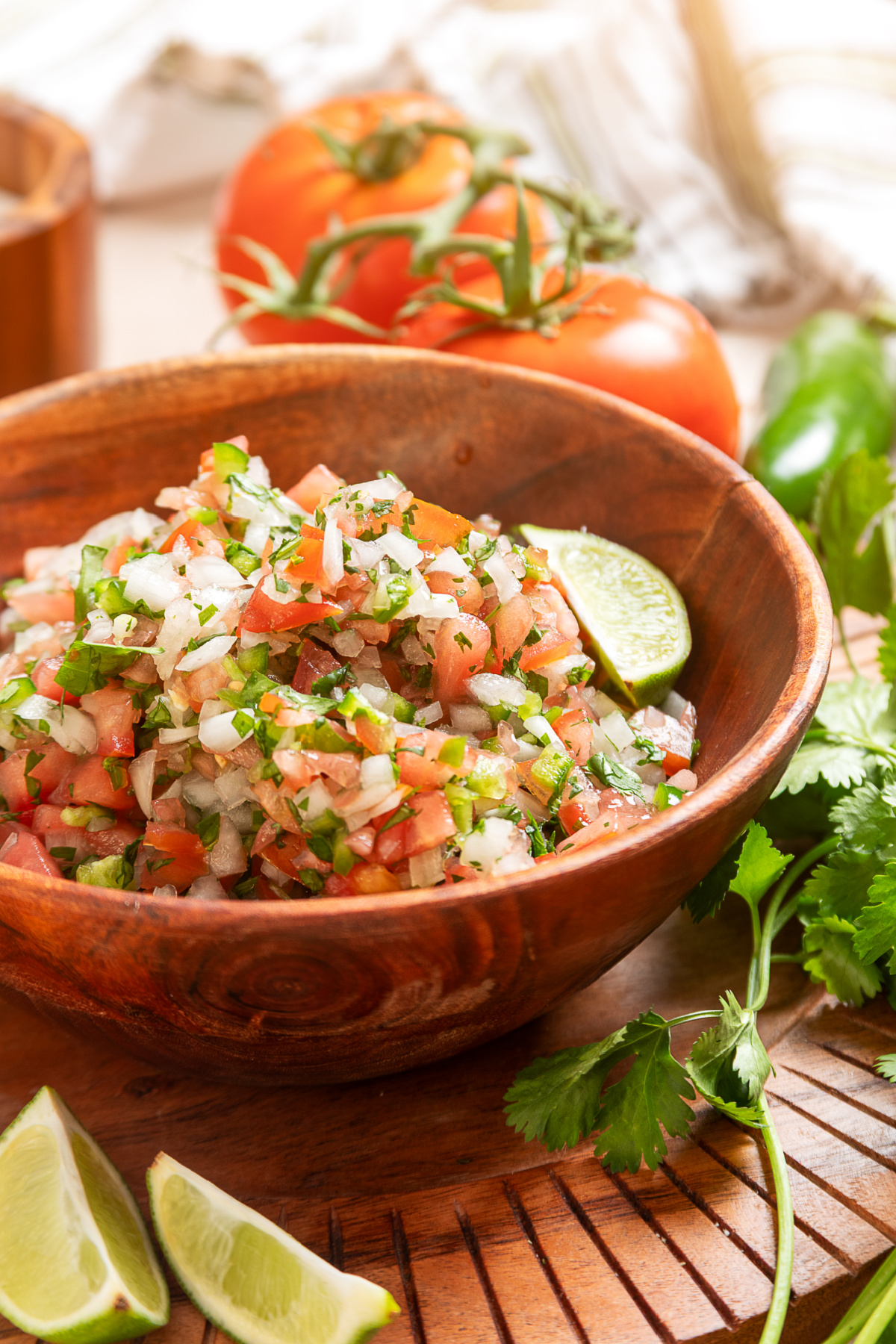 Chunky pico de gallo with lime, cilantro, and seeded tomatoes Fresh pico de gallo with diced tomatoes, onion, jalapeño, cilantro, and lime served in a wooden bowl