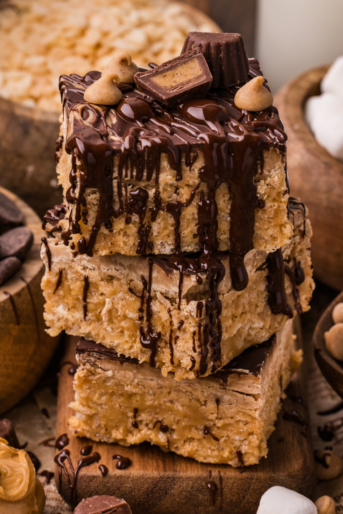 Stacked marbled peanut butter crunch bars drizzled with melted chocolate and topped with peanut butter cups