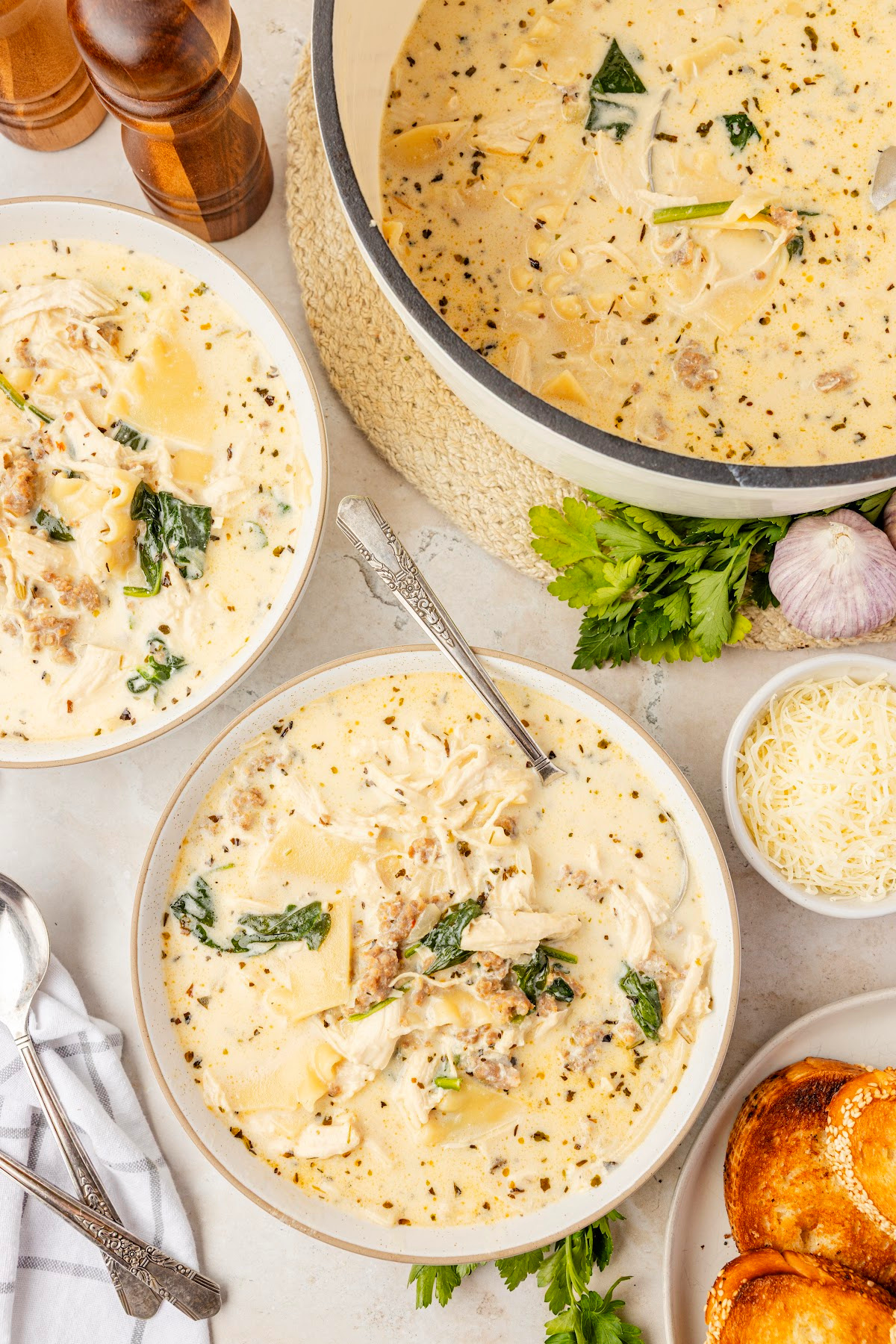 Lasagna soup with ricotta, spinach, sausage, chicken, and creamy white broth Lasagna soup with ricotta, spinach, sausage, chicken, and broken lasagna noodles served in bowls with creamy white broth