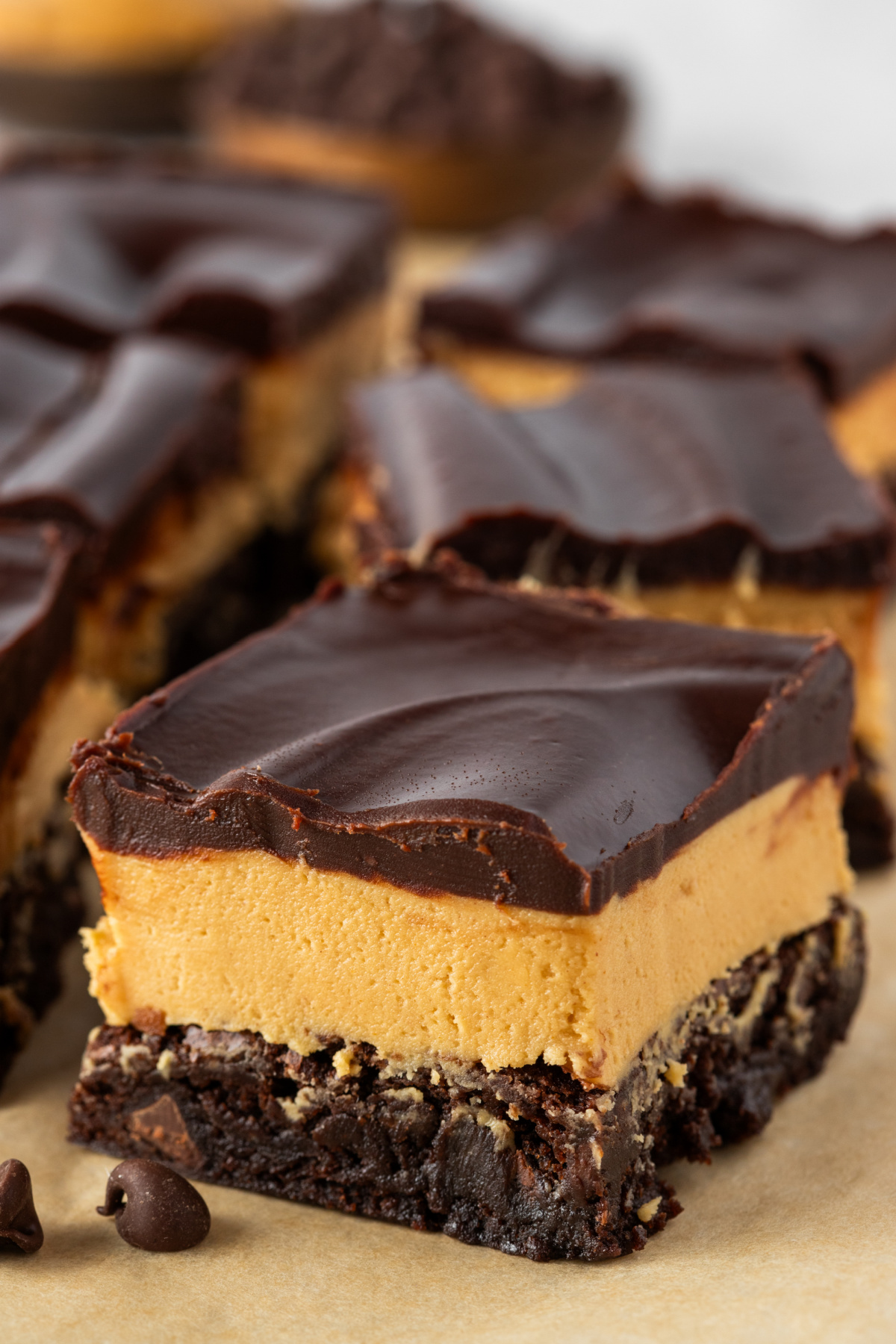 Layered Buckeye brownies with thick peanut butter filling and glossy chocolate topping
