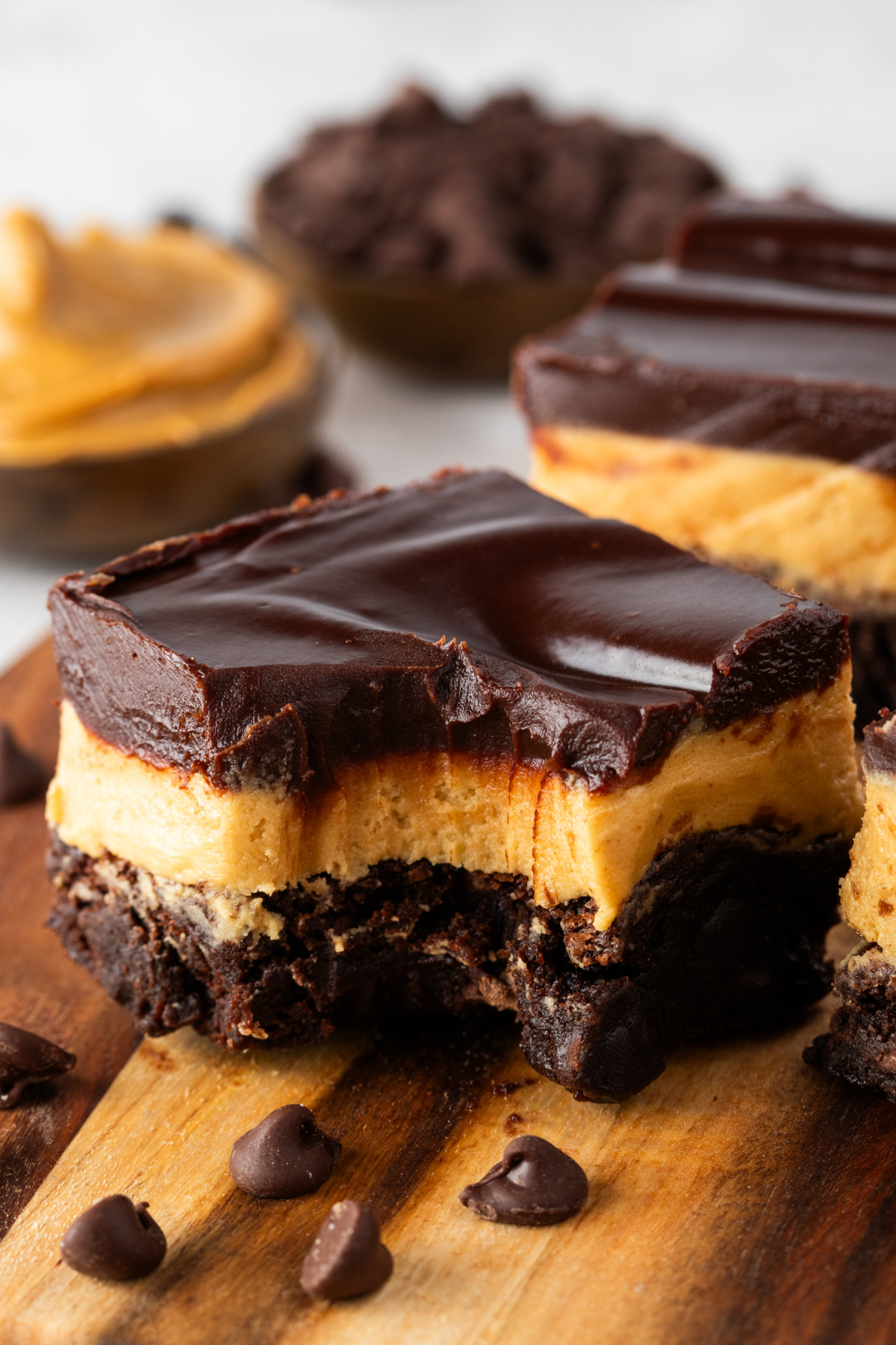 Layered Buckeye brownies with thick peanut butter filling and chocolate ganache topping