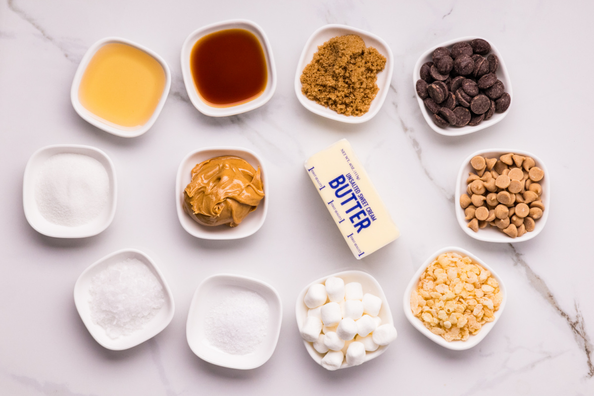 Ingredients for marbled peanut butter crunch bars including marshmallows, peanut butter, chocolate chips, puffed rice cereal, and peanut butter chips