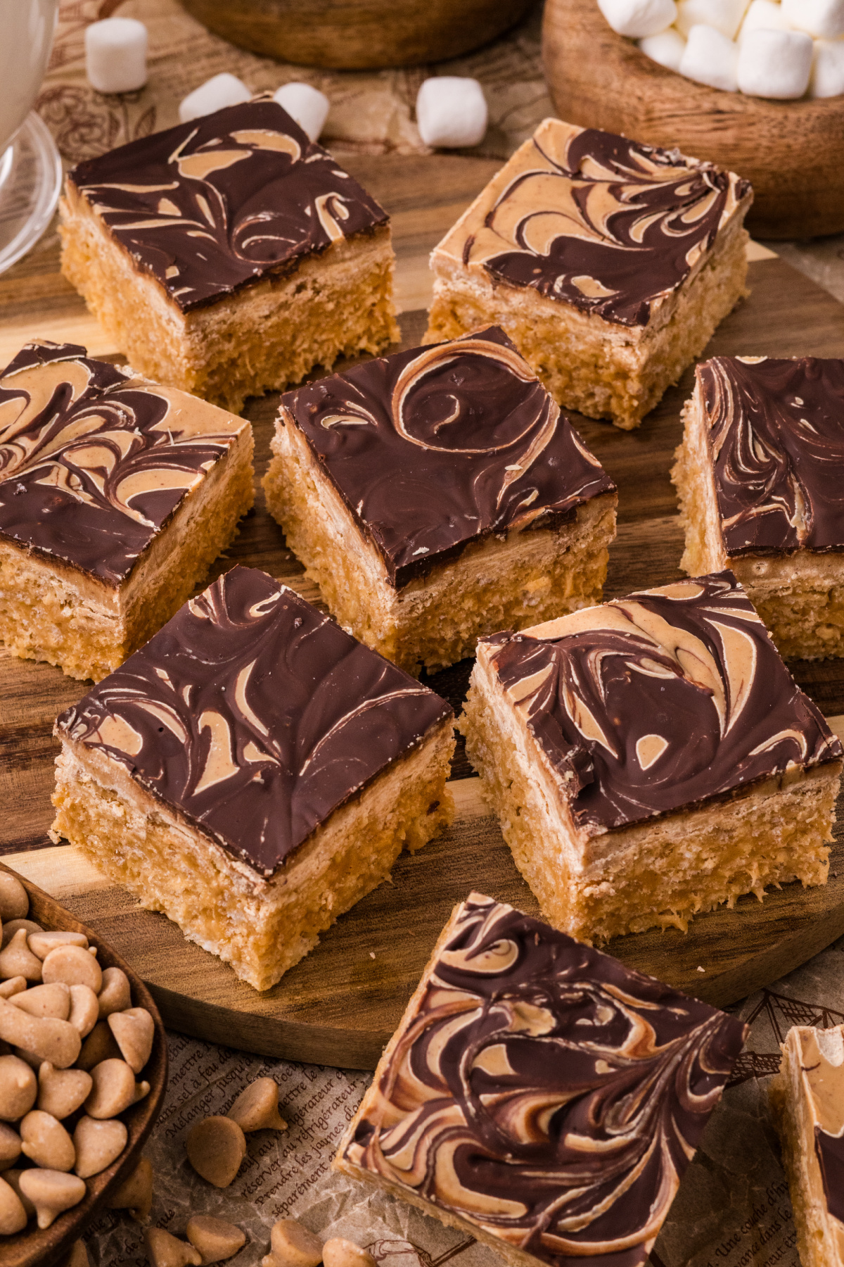 Marbled peanut butter crunch bars arranged on a wooden board with thick chocolate swirls and chewy marshmallow centers