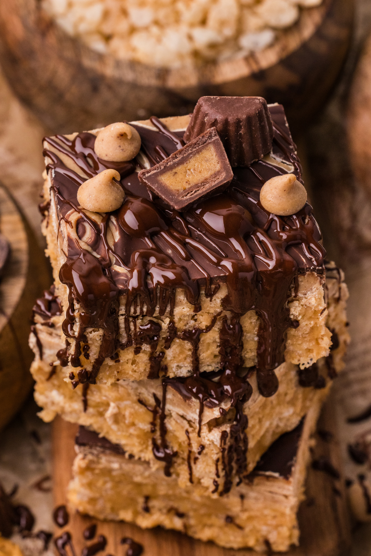 Gooey peanut butter marshmallow bars stacked with melted chocolate drizzle and peanut butter cup topping