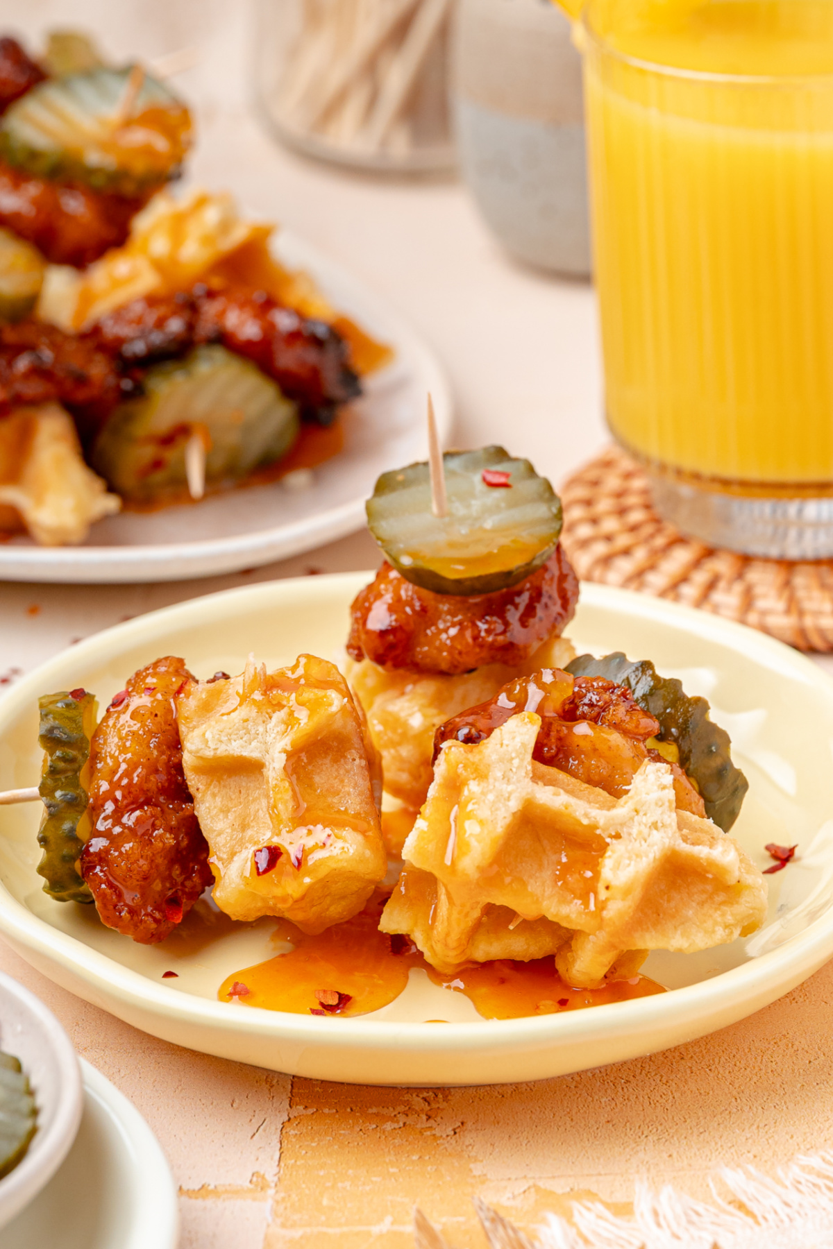 Party Appetizer Bites With Peach Hot Honey Glaze Party appetizer bites with crispy chicken, waffles, dill pickles, and peach hot honey glaze.