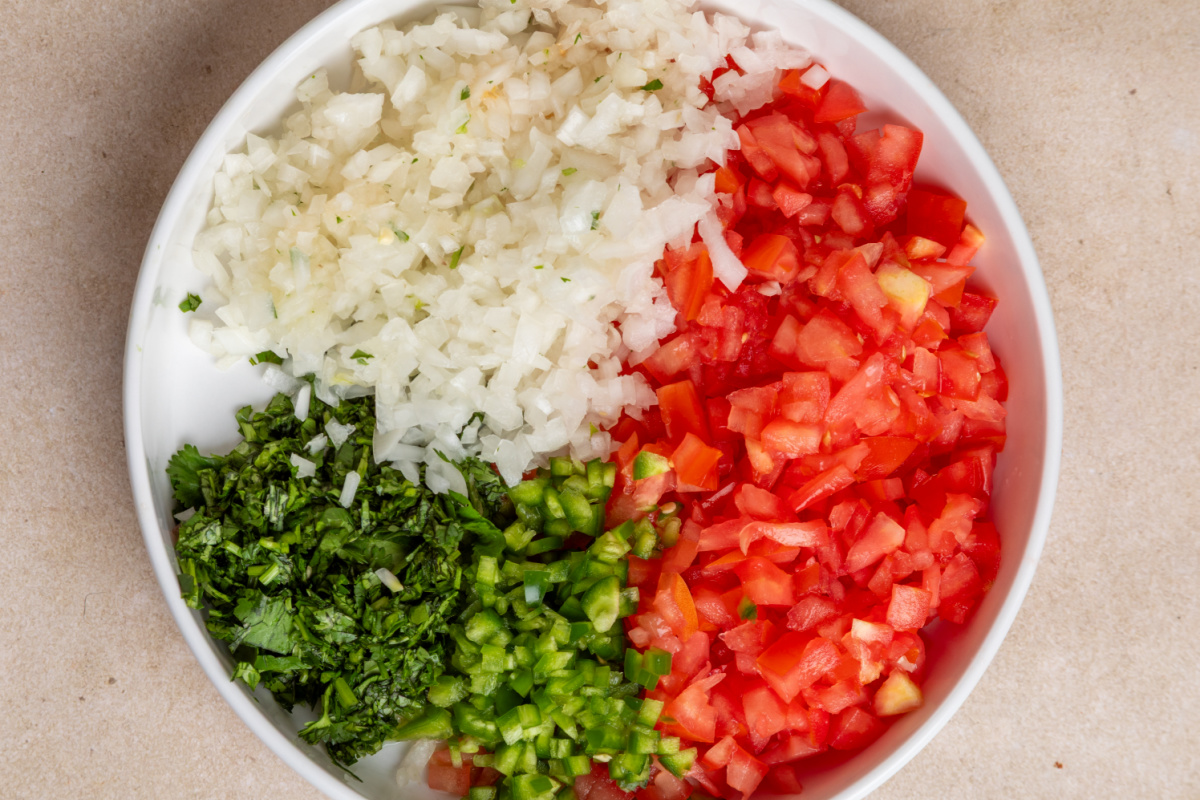 Prepped ingredients for chunky homemade pico de gallo Diced tomatoes, white onion, jalapeño, garlic, and cilantro prepared for homemade pico de gallo