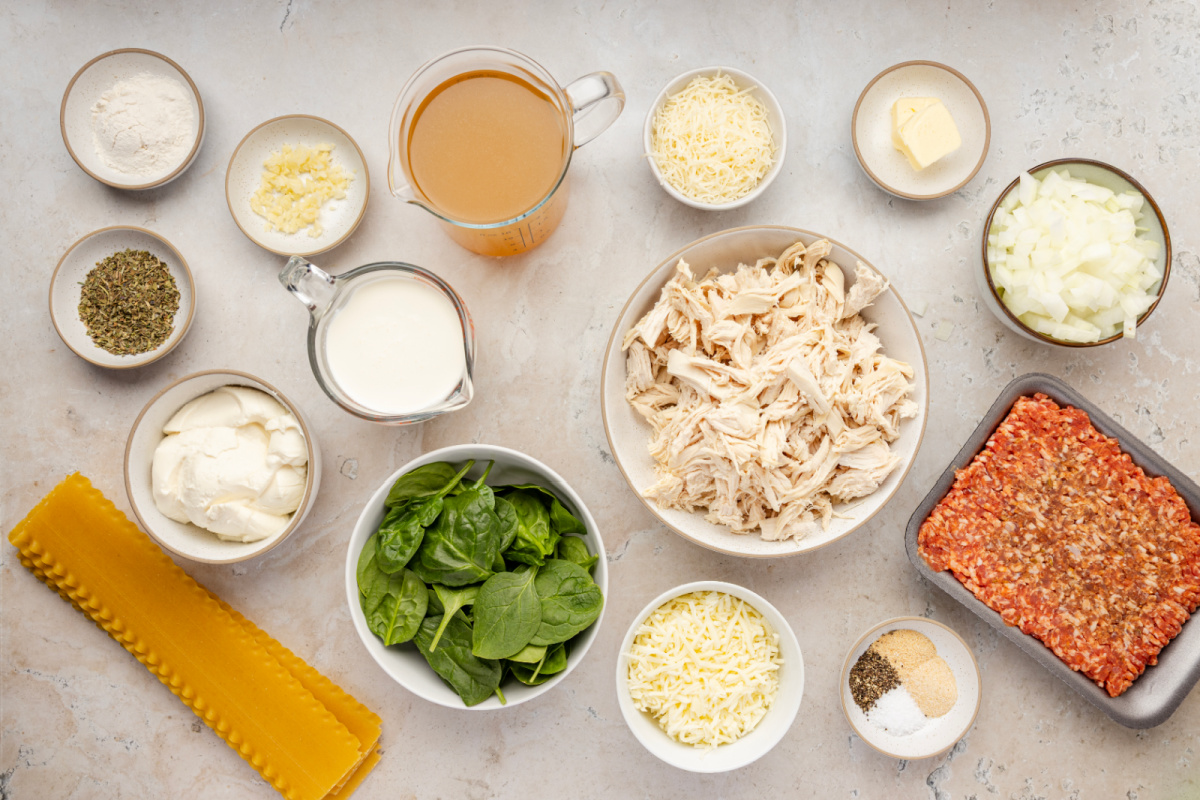 Ingredients for White Lasagna Soup with ricotta, sausage, chicken, spinach, and lasagna noodles Ingredients for White Lasagna Soup including sausage, chicken, spinach, ricotta, mozzarella, Parmesan, lasagna noodles, cream, and chicken stock