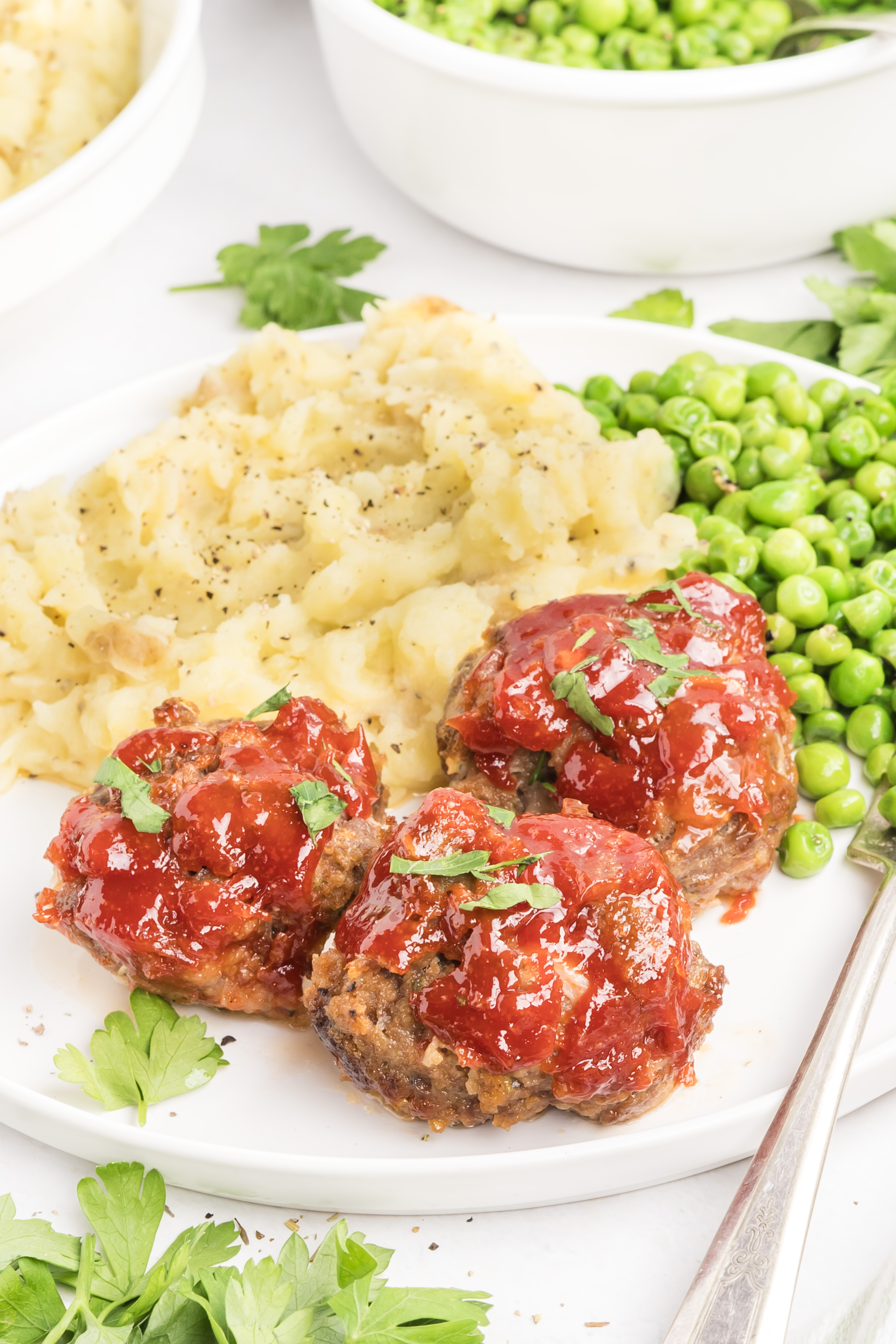 Mini meatloaf recipe with tomato glaze, mashed potatoes, and peas Mini meatloaf recipe served with mashed potatoes and peas