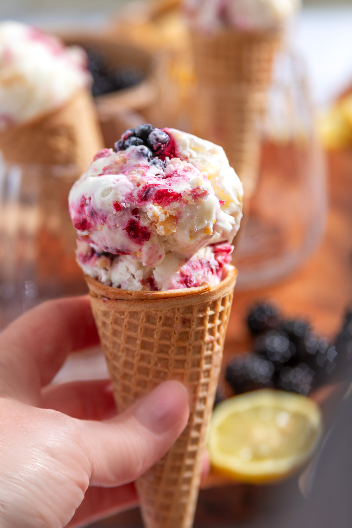 This no-churn Blackberry Crumble à la Mode Ice Cream is inspired by blackberry crumble served with vanilla ice cream. Blackberry Crumble à la Mode Ice Cream in a waffle cone with blackberry ribbons and buttery shortbread crumble.