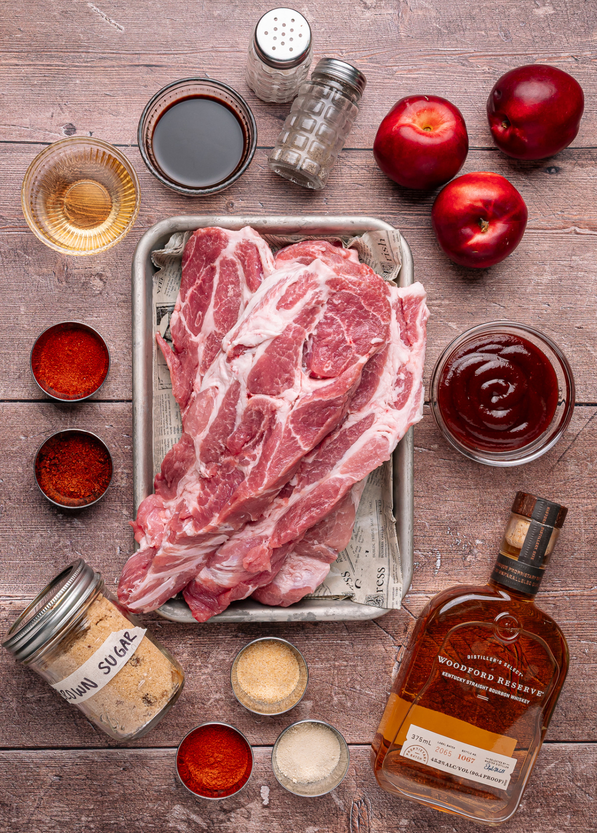 Everything needed to make bourbon peach country style ribs, including pork shoulder ribs, fresh peaches, bourbon, barbecue sauce, and seasonings. Ingredients for bourbon peach country style ribs including country style pork ribs, fresh peaches, bourbon, barbecue sauce, and spices
