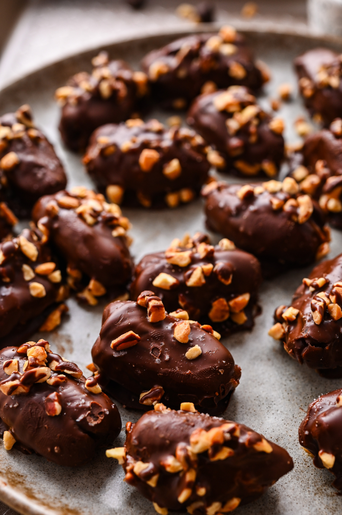 Chocolate peanut butter stuffed dates ready to serve Chocolate peanut butter stuffed dates topped with chopped peanuts on a serving platter