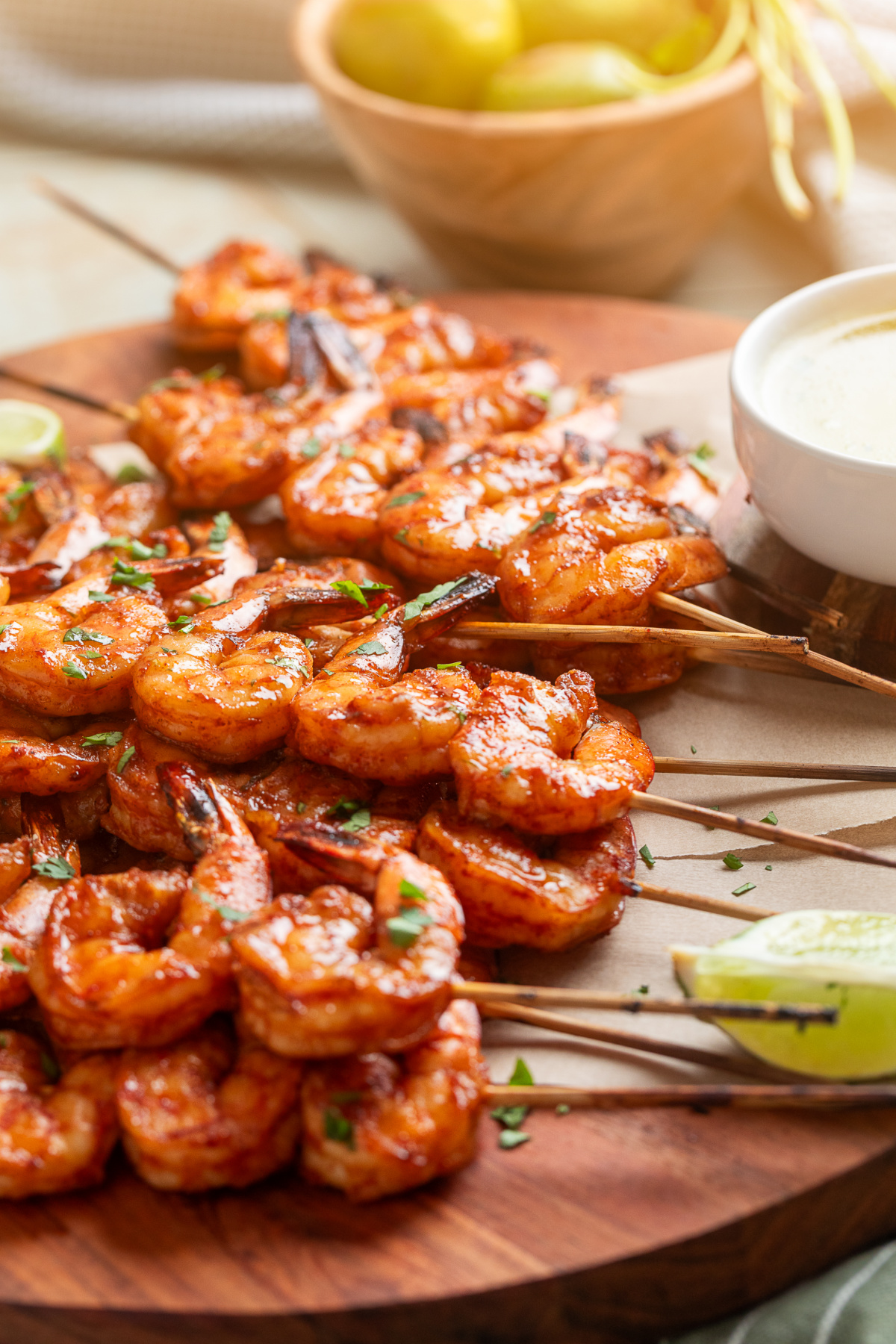 Grilled shrimp skewers served with garlic lime butter dipping sauce and lime wedges
