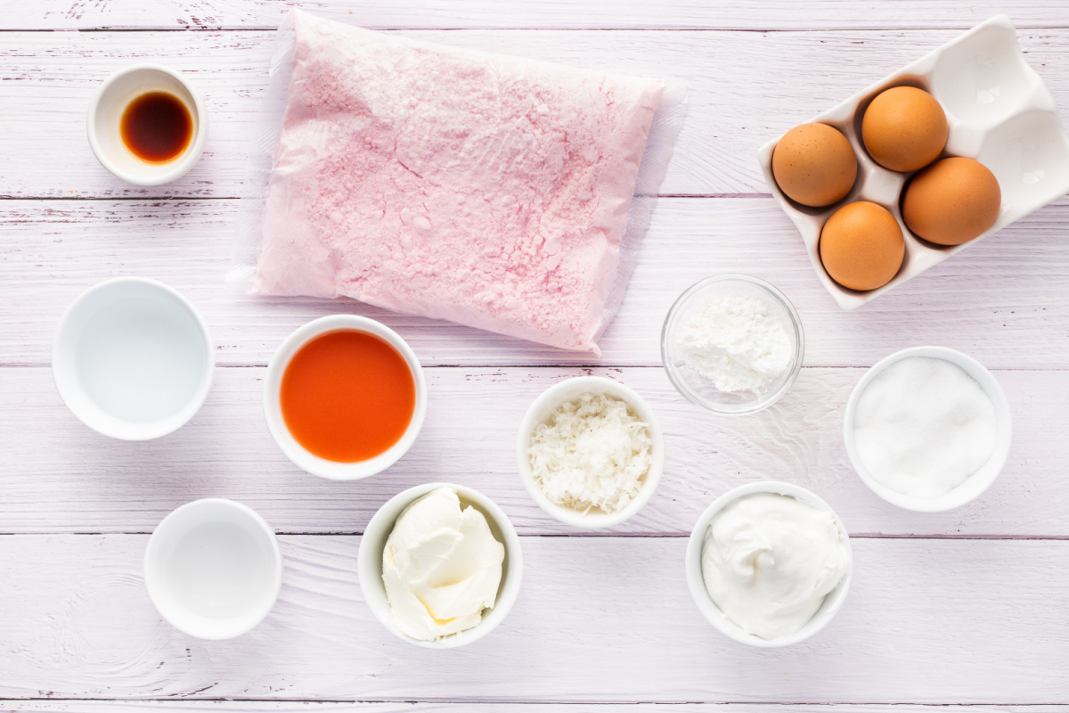 Ingredients for guava glazed cream cheese cupcakes including strawberry cake mix, guava nectar, cream cheese, eggs, coconut, sugar, and Cool Whip