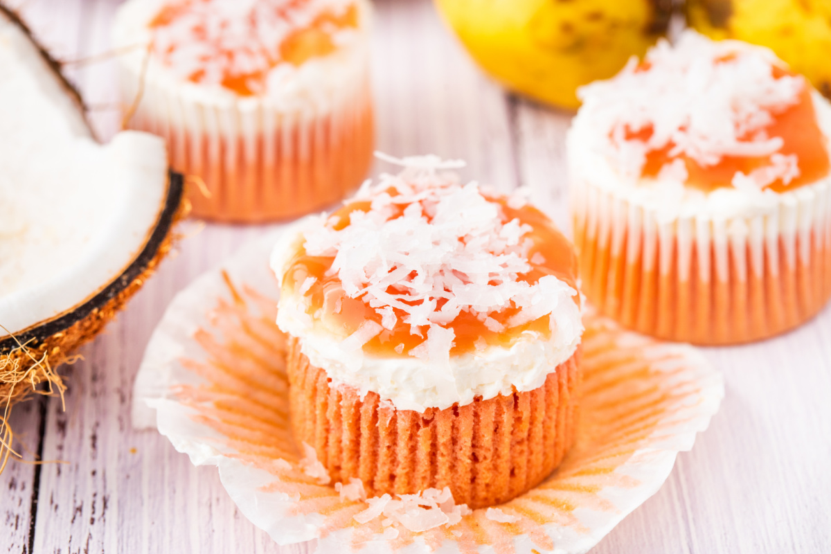 Hawaiian guava cake cupcakes topped with cream cheese frosting, guava glaze, and coconut