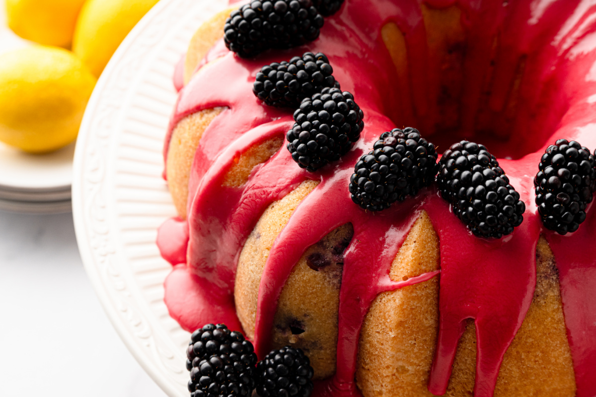 Fresh blackberry glaze drizzled over lemon blackberry Bundt cake Close-up of lemon blackberry Bundt cake covered with fresh blackberry glaze and topped with whole blackberries