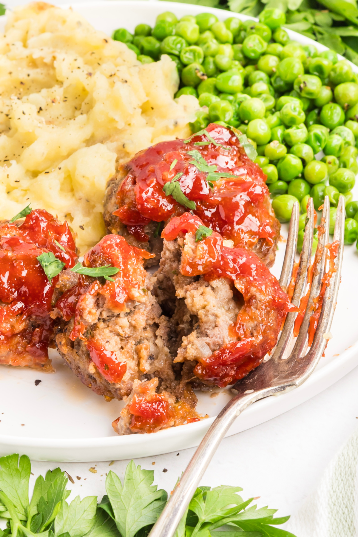 Mini meatloaf broken open to show the interior texture Inside of a mini meatloaf showing the tender texture beneath the tomato glaze