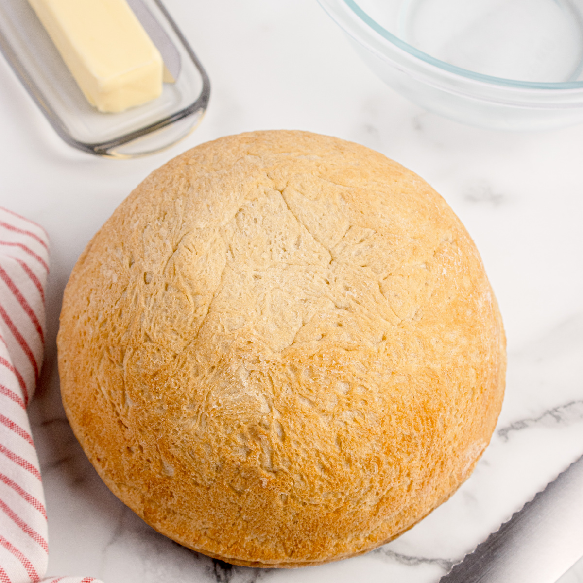 No-knead peasant bread baked in a Pyrex bowl with a golden crust