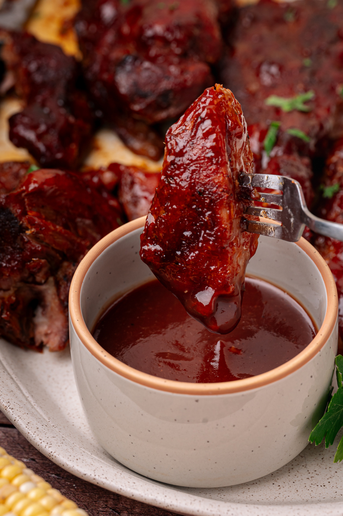 A tender oven baked country style rib dipped into smooth peach bourbon barbecue sauce before serving. Oven baked country style ribs dipped into peach bourbon barbecue sauce