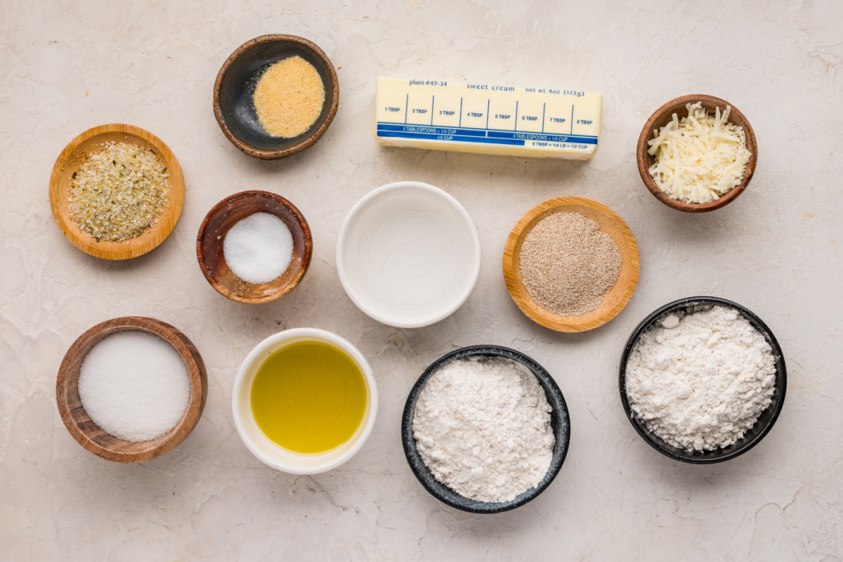 Everything needed to make homemade Parmesan bread bites from scratch Ingredients for Parmesan bread bites including flour, yeast, Parmesan cheese, butter, olive oil, sugar, salt, and garlic powder