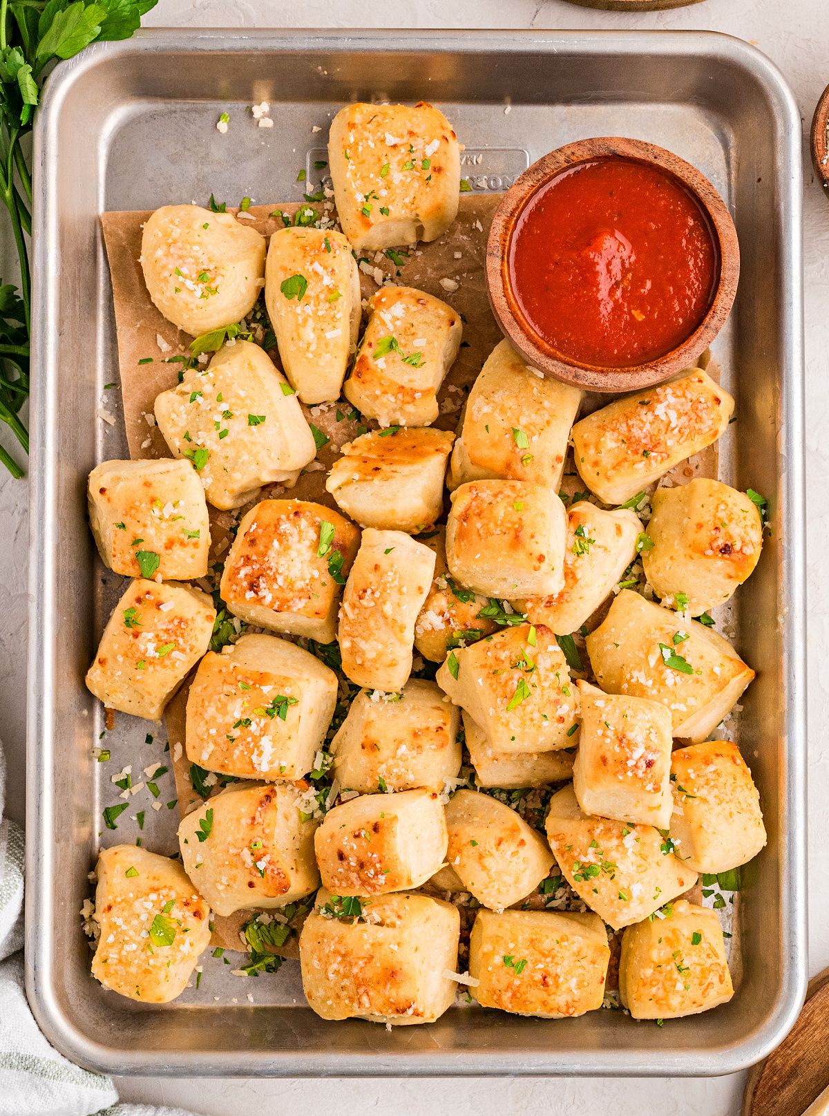 Soft Parmesan bread bites dipped in garlic butter before baking and served with marinara sauce Parmesan bread bites baked until golden brown and served with marinara sauce for dipping
