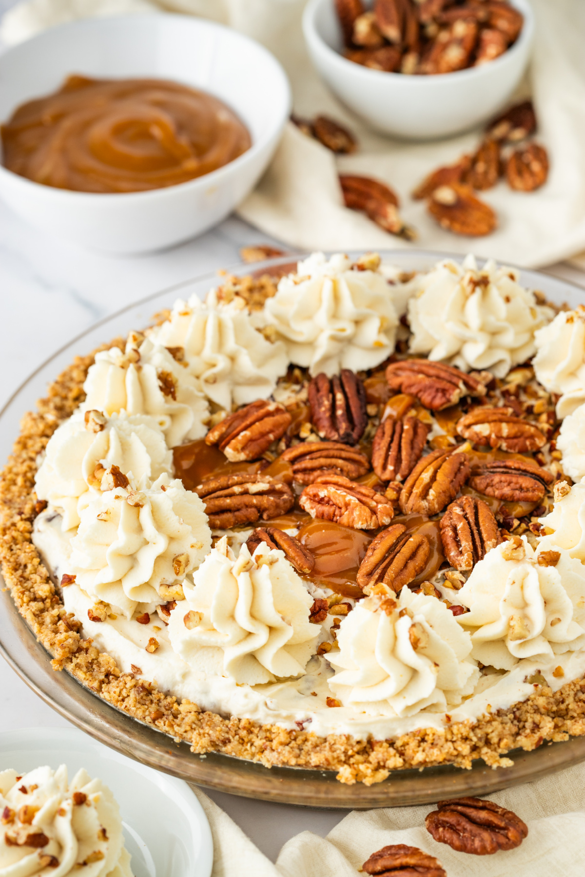 Creamy Pecan Pie Pecan cream pie topped with toasted pecans, whipped cream, caramel drizzle, and a pecan crust