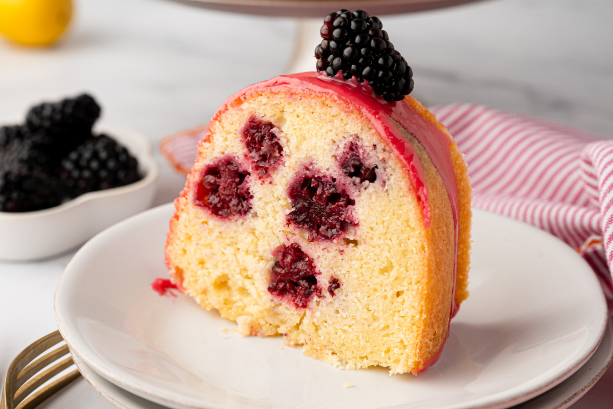 Single slice of lemon blackberry Bundt cake showing blackberry pockets throughout the crumb slice-of-lemon-blackberry-bundt-cake