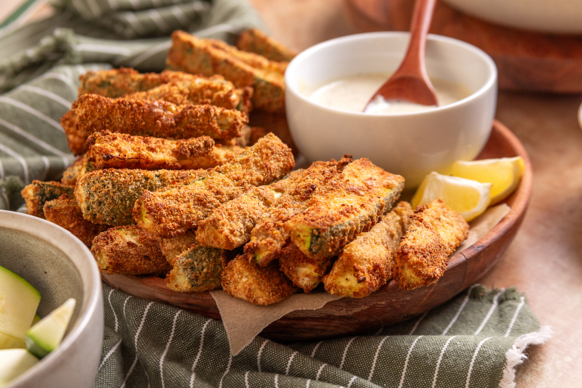 Air Fryer Zucchini Fries Served with Lemon Garlic Aioli Serving platter of air fryer zucchini fries with homemade lemon garlic aioli and lemon wedges.