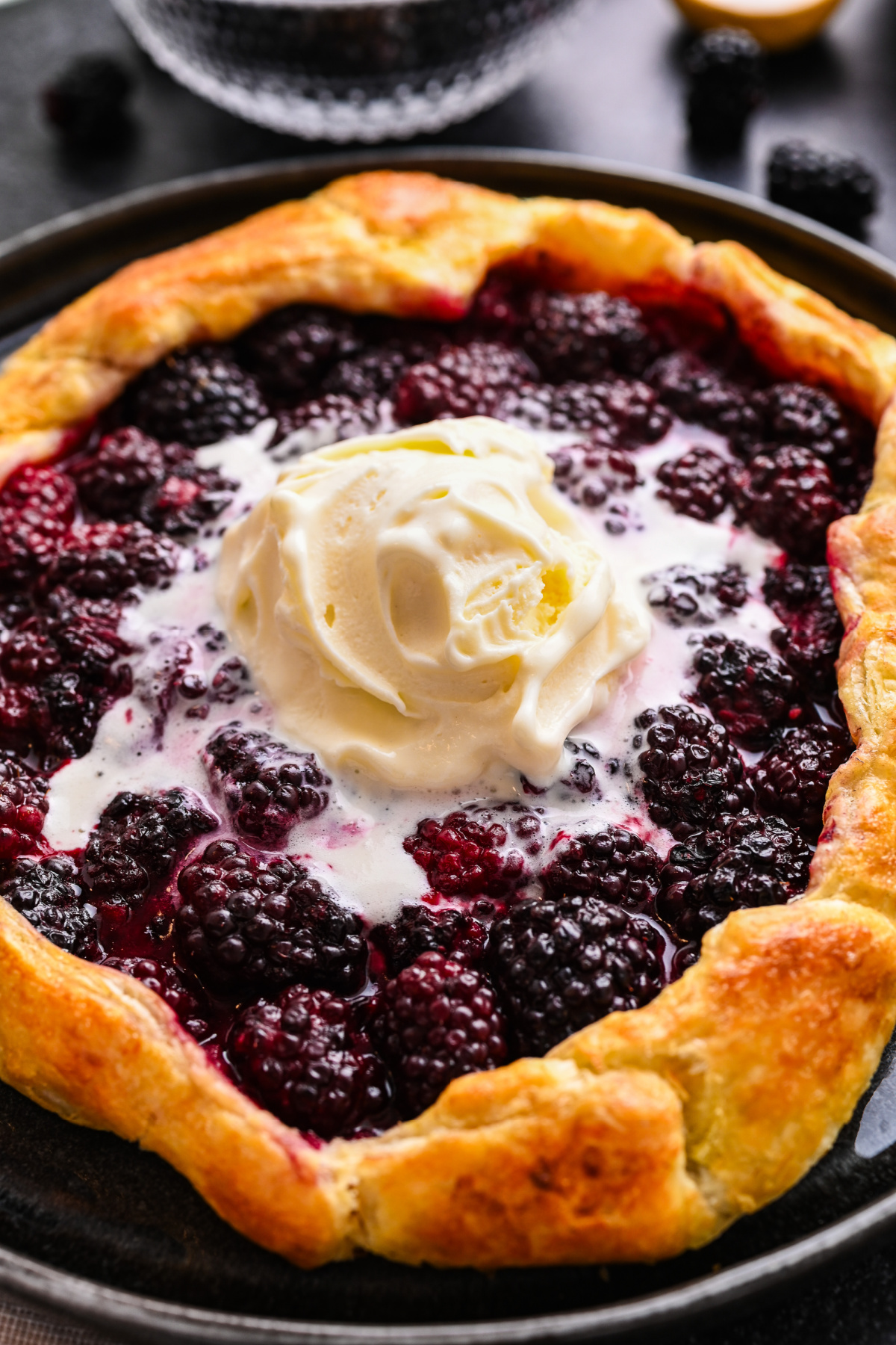 Close-up of Blackberry Puff Pastry Galette with melting vanilla ice cream. Close-up of blackberry puff pastry galette served warm with vanilla ice cream.