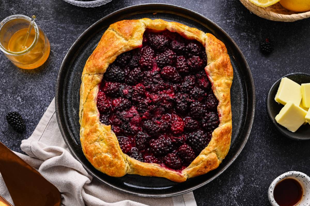 Blackberry Puff Pastry Galette baked until golden with a naturally juicy blackberry filling. Overhead view of a blackberry puff pastry galette made with fresh blackberries and honey.