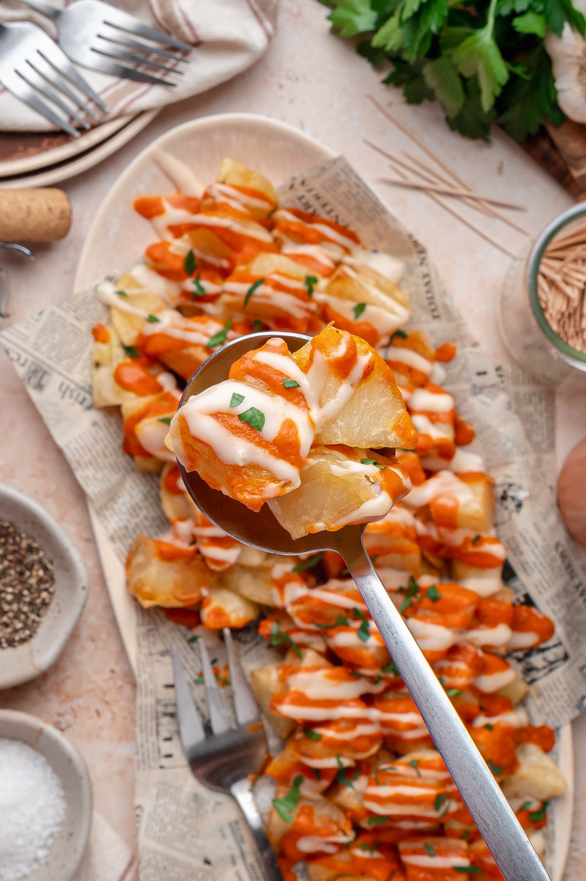 Bravas Sauce and Garlic Aioli Close-up of crispy fried potatoes topped with smoky bravas sauce and garlic aioli.