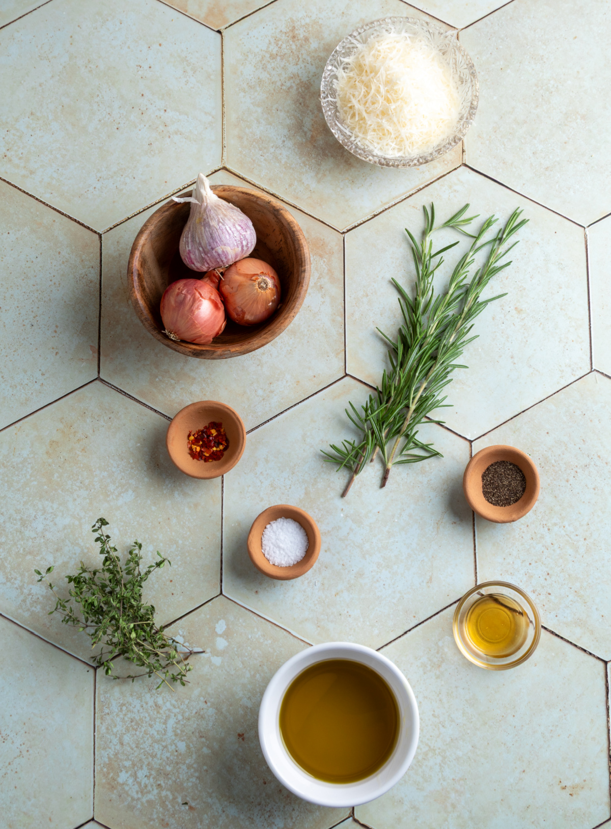 Bread Dipping Oil ingredients Ingredients for bread dipping oil including olive oil, shallots, garlic, rosemary, thyme, Parmesan, honey, salt, pepper, and red pepper flakes.