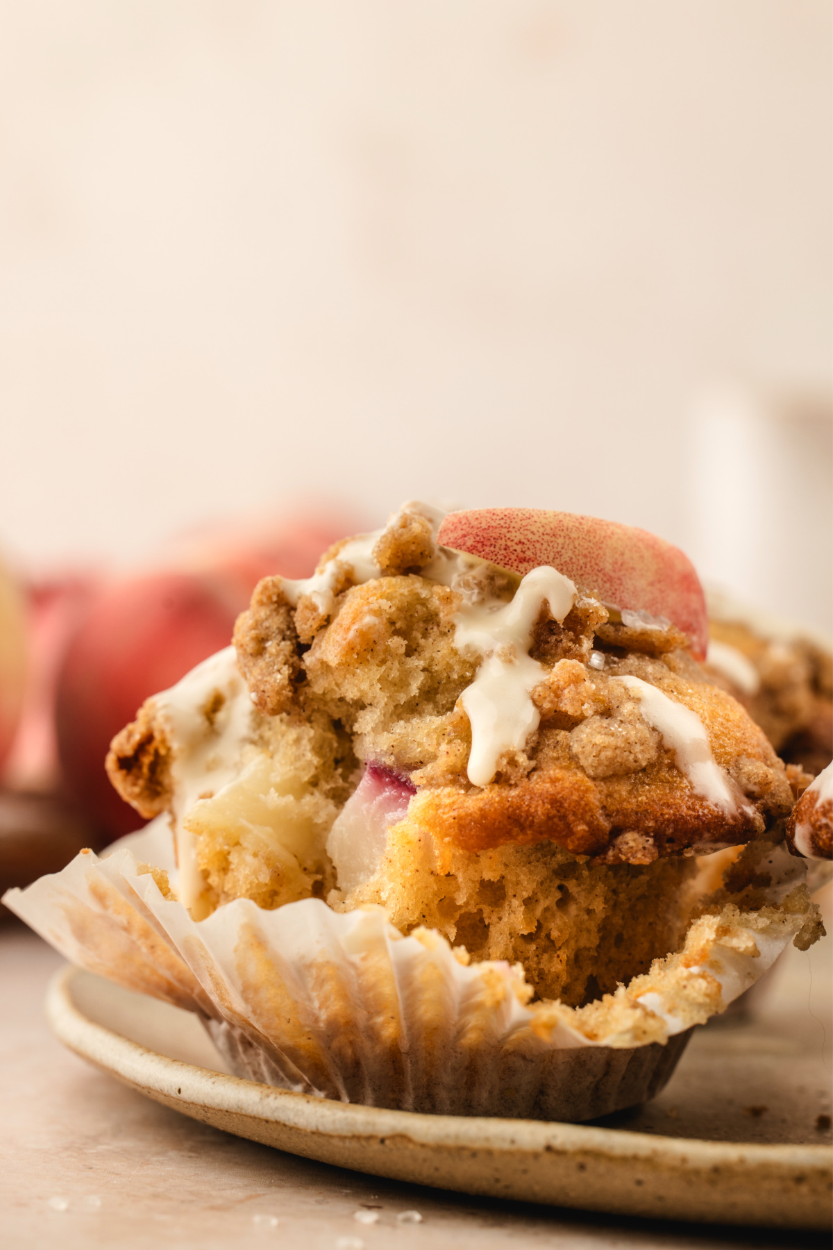 Brown butter peach coffee cake muffin with fresh peaches, cinnamon streusel, and vanilla glaze