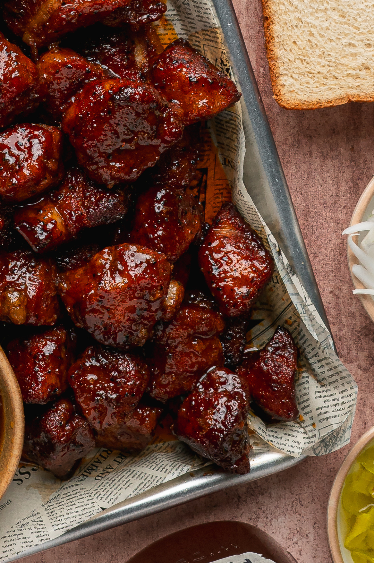 Close-up of caramelized pork belly burnt ends coated in a glossy peach tea glaze.