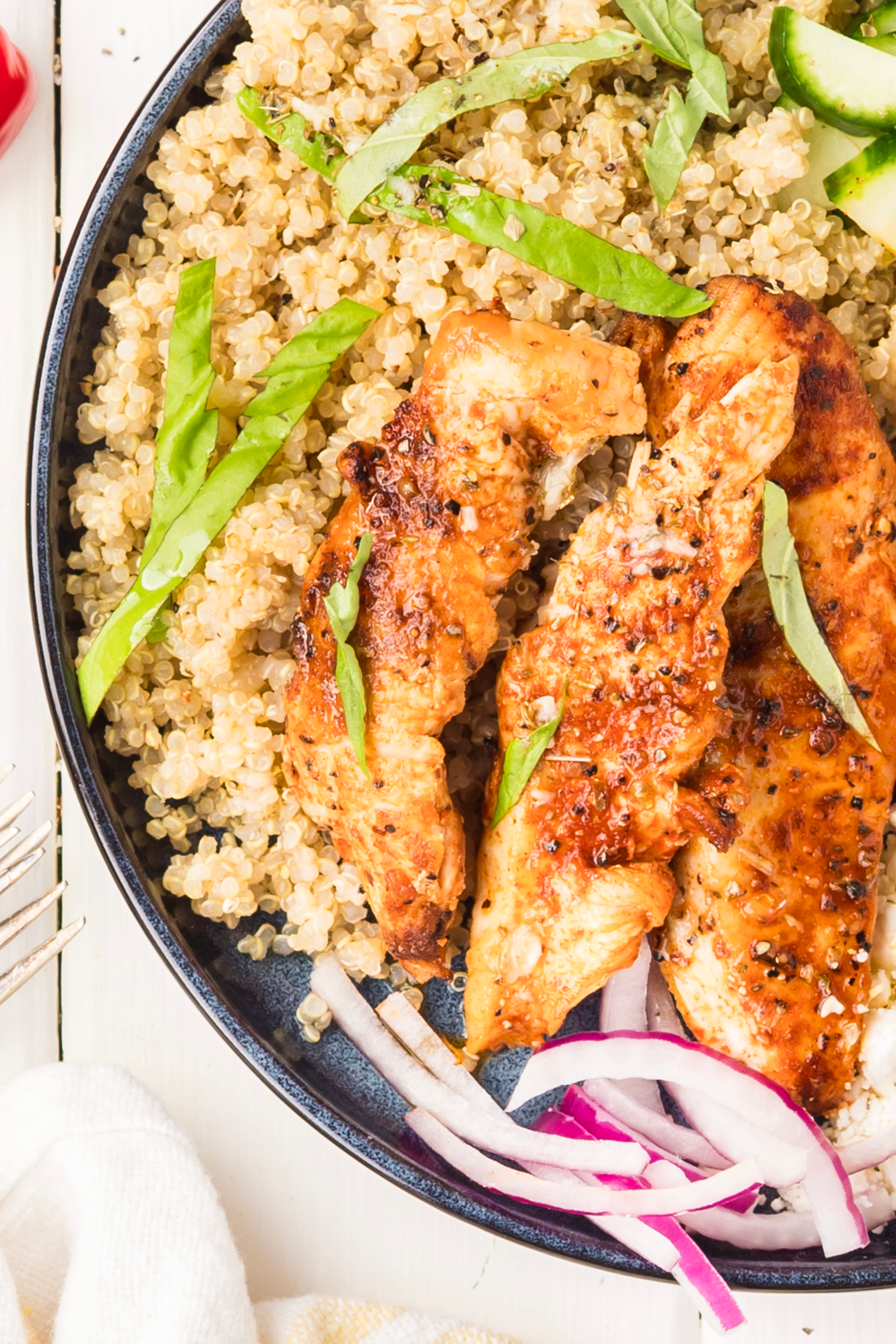 Grilled Chicken and Quinoa Bowl Mediterranean chicken bowl with grilled chicken, quinoa, cucumber, tomatoes, feta, Kalamata olives, red onion, basil, and lemon vinaigrette.