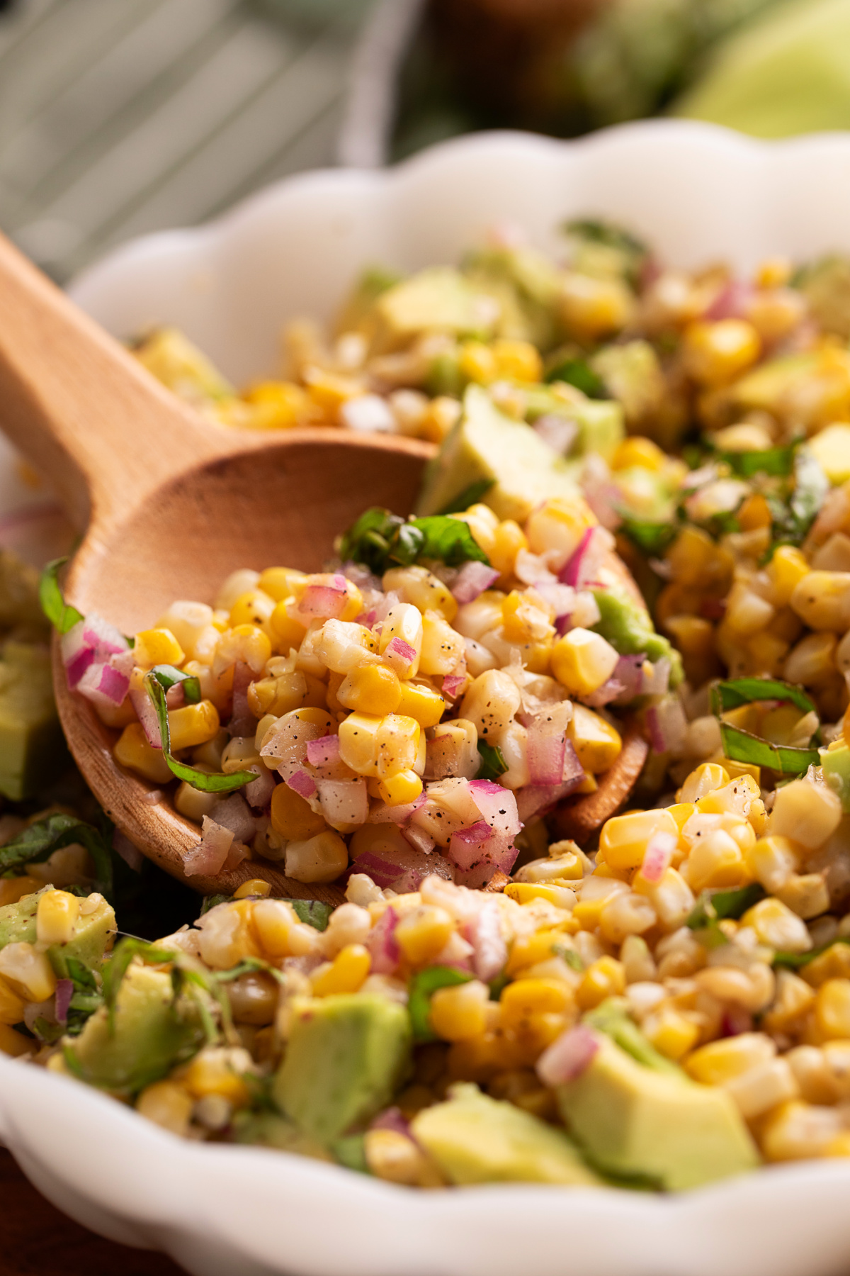 Grilled corn salad with avocado and basil made with charred fresh corn, avocado, red onion, and basil.