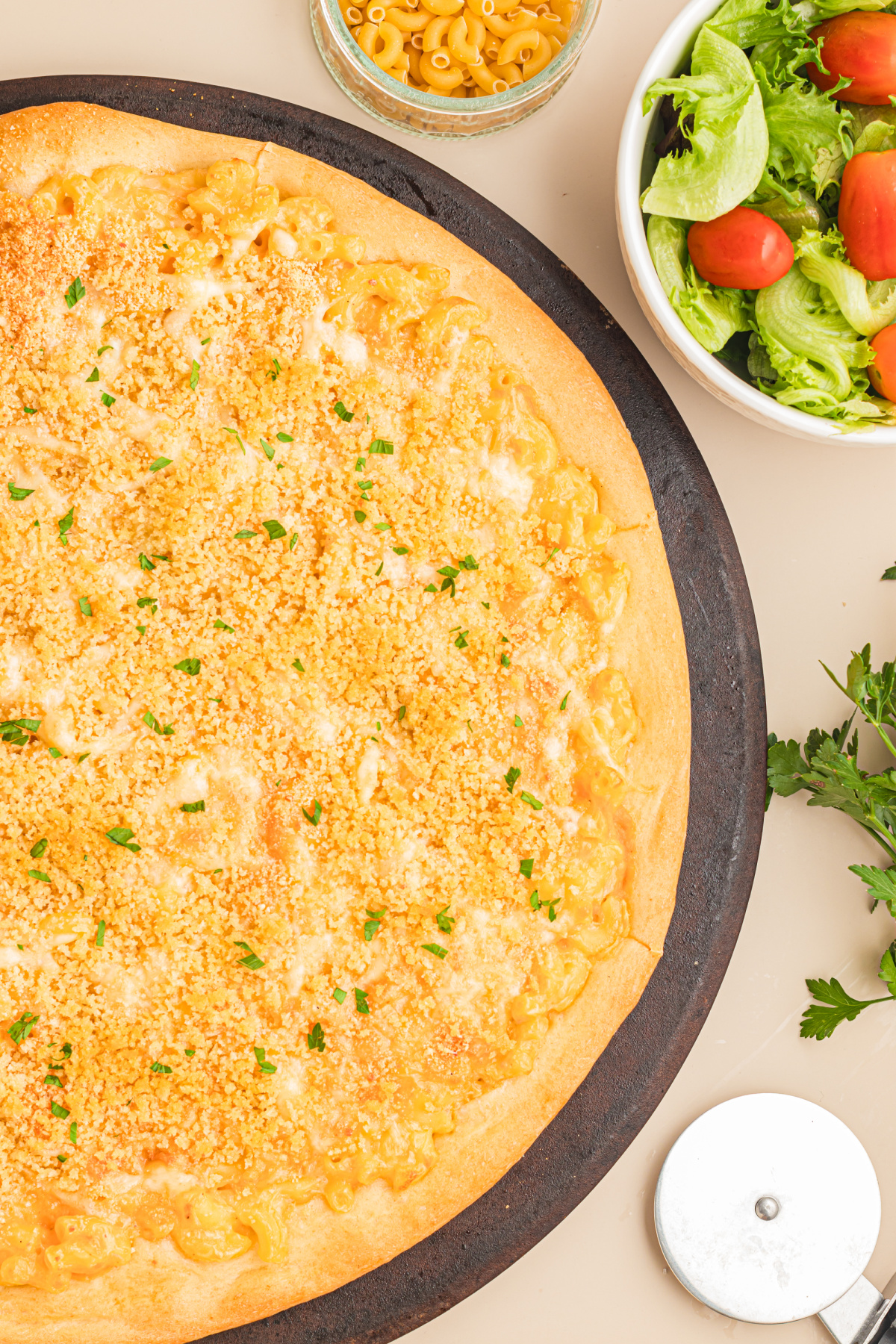 Homemade mac and cheese pizza fresh from the oven with a golden buttery breadcrumb topping and crisp pizza crust.