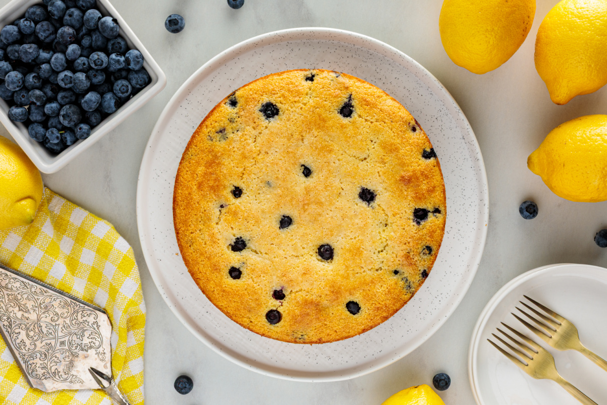 An overhead look at lemon blueberry cornbread with a golden crust and fresh blueberries throughout. Overhead view of lemon blueberry cornbread baked until golden brown with fresh blueberries baked into the top.
