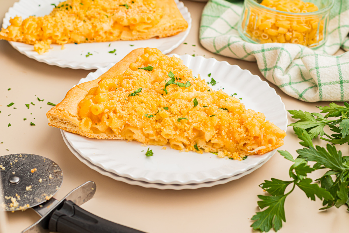 Single slice of homemade mac and cheese pizza with creamy cheddar macaroni, buttery panko breadcrumbs, and a crisp pizza crust.