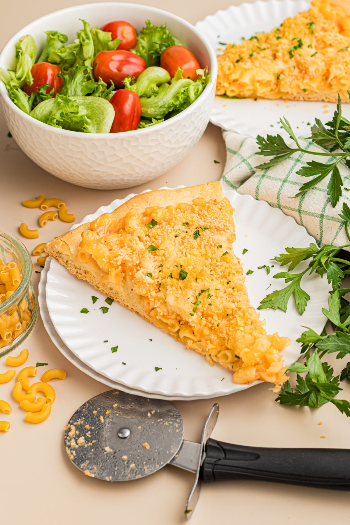 Slice of homemade mac and cheese pizza served with a fresh green salad for an easy family lunch or dinner.
