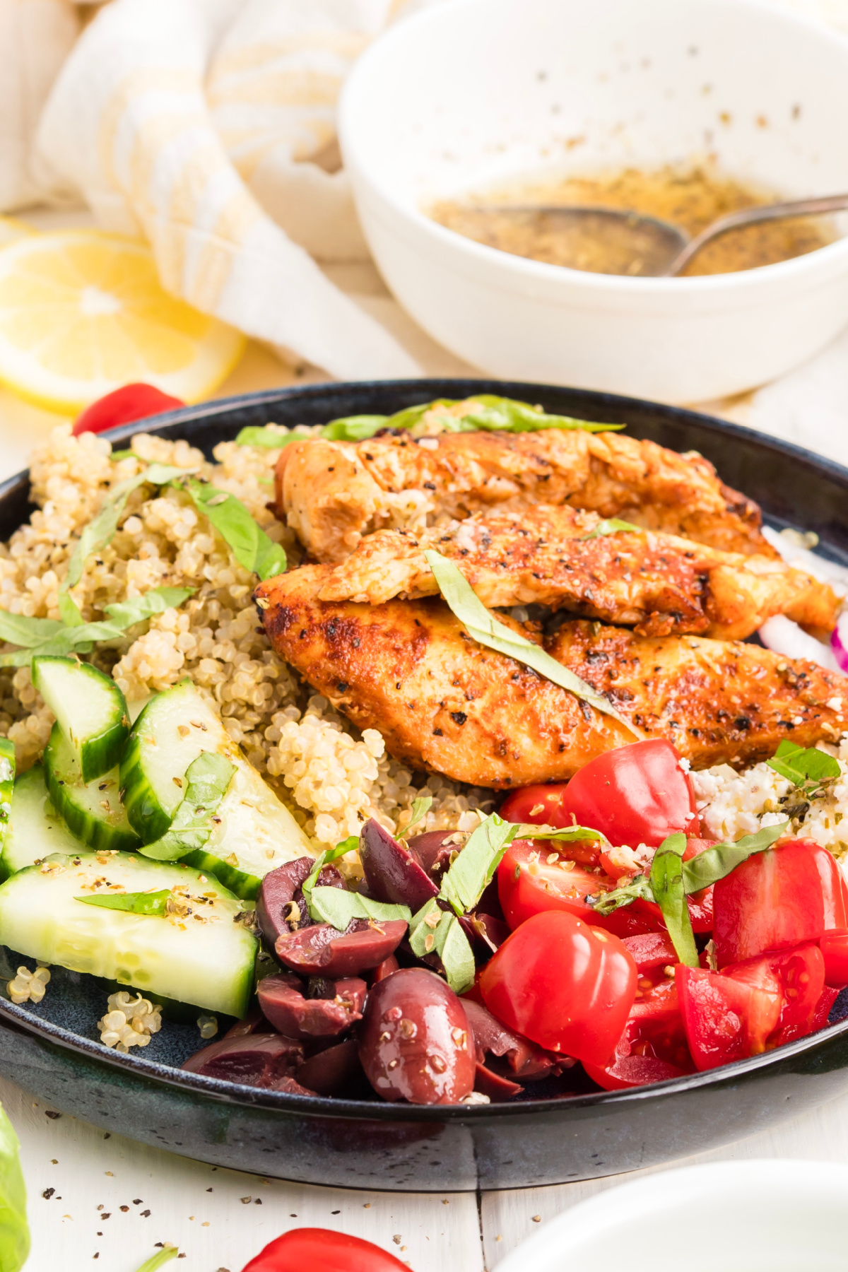 Mediterranean Grilled Chicken Quinoa Bowl Mediterranean grilled chicken quinoa bowl with cucumber, cherry tomatoes, Kalamata olives, feta, fresh basil, and lemon vinaigrette.
