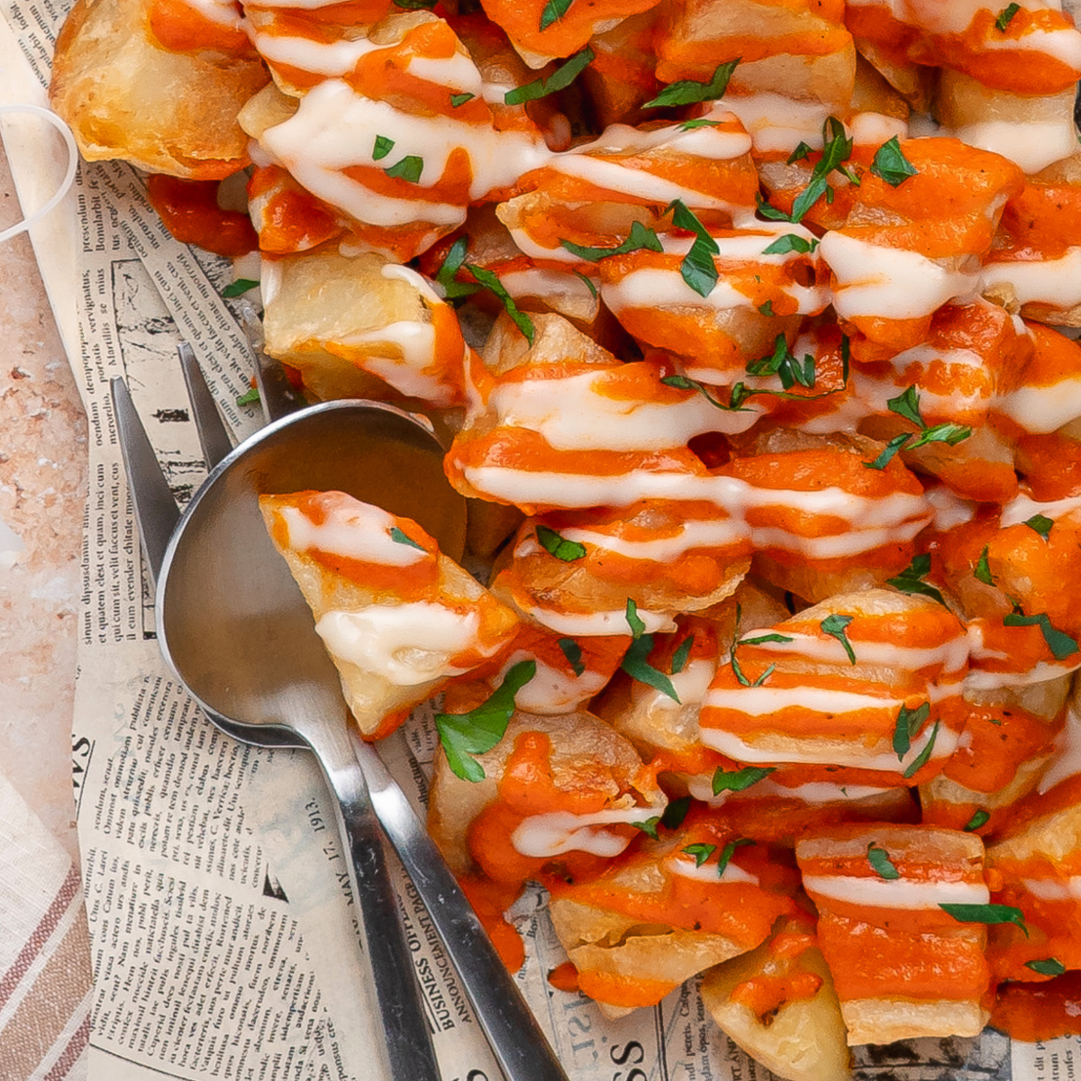 Patatas bravas with homemade bravas sauce, garlic aioli, and fresh parsley.