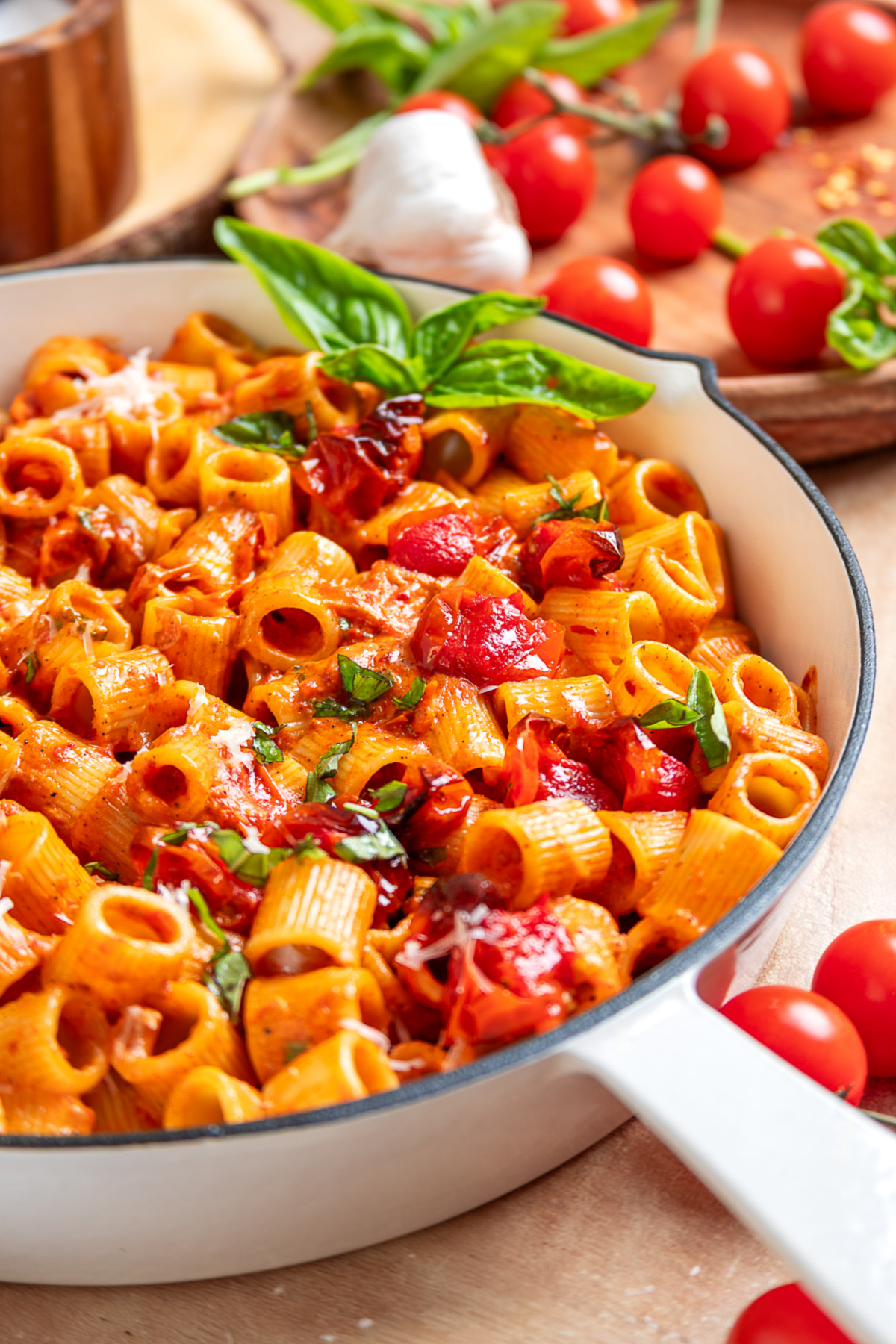 Spicy roasted tomato vodka pasta in a white skillet topped with roasted grape tomatoes, fresh basil, and grated Parmesan cheese. Spicy roasted tomato vodka pasta in a white skillet topped with roasted grape tomatoes, fresh basil, and grated Parmesan cheese.