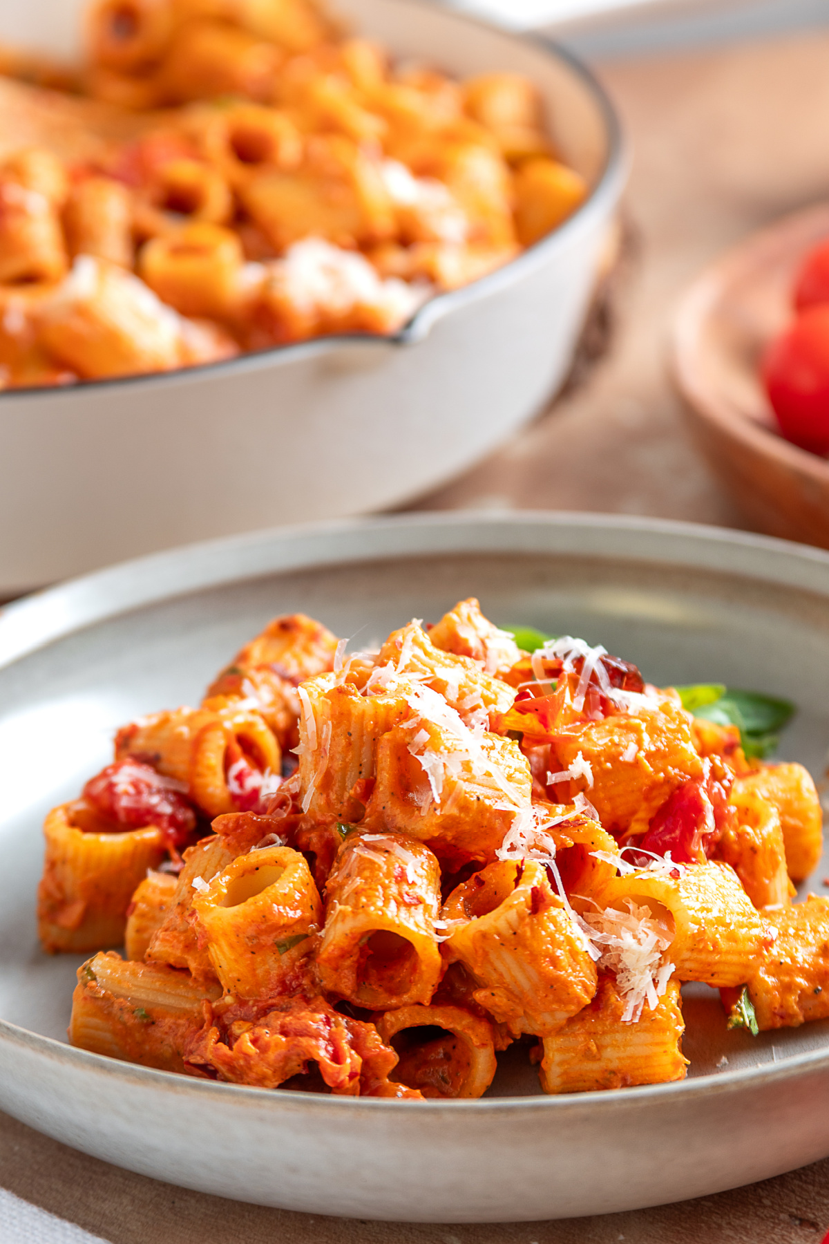 A plated serving of spicy roasted tomato vodka pasta with Parmesan and roasted grape tomatoes. A serving of spicy roasted tomato vodka pasta with roasted grape tomatoes and freshly grated Parmesan cheese.