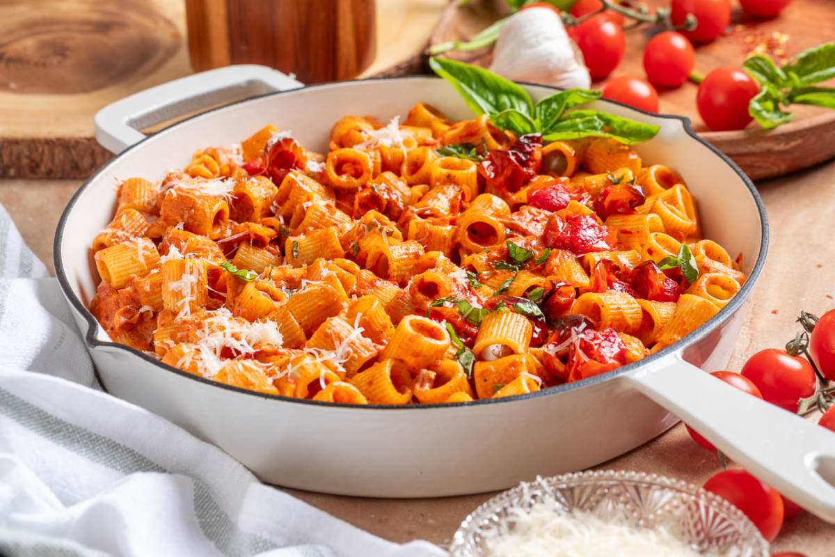 Spicy roasted tomato vodka pasta served in a skillet with roasted grape tomatoes and fresh basil. Spicy roasted tomato vodka pasta in a skillet with roasted grape tomatoes, fresh basil, and grated Parmesan cheese.