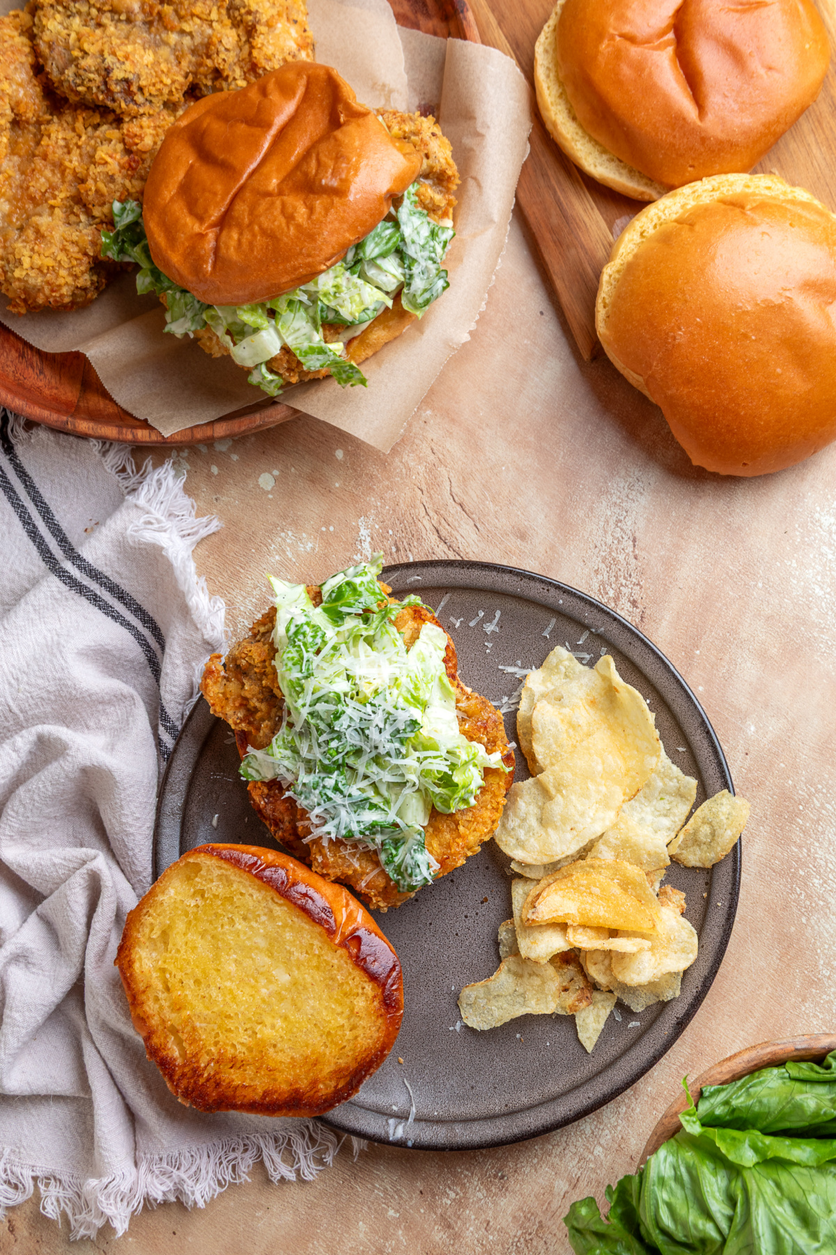 Air fryer chicken Caesar sandwich Overhead view of an air fryer chicken Caesar sandwich with crispy potato chip-crusted chicken, homemade Caesar salad, toasted brioche bun, and potato chips.