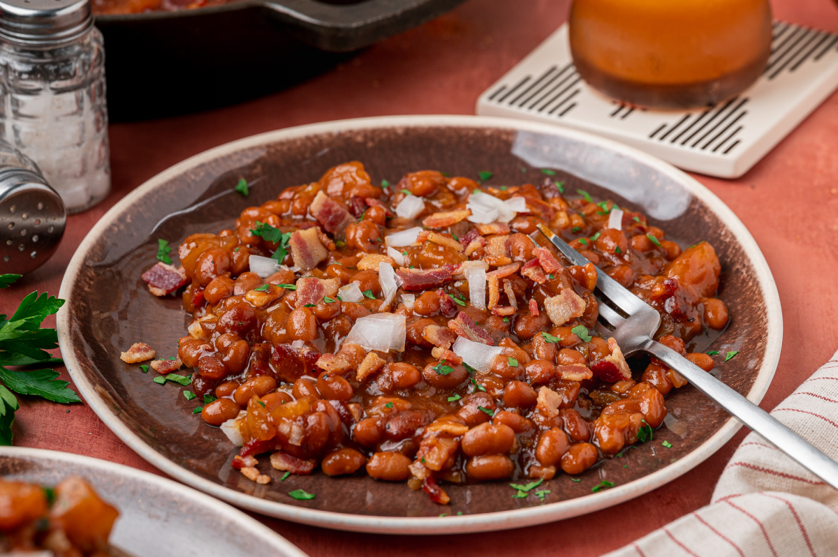 Baked beans with apple pie filling, bacon and diced onion served on a plate