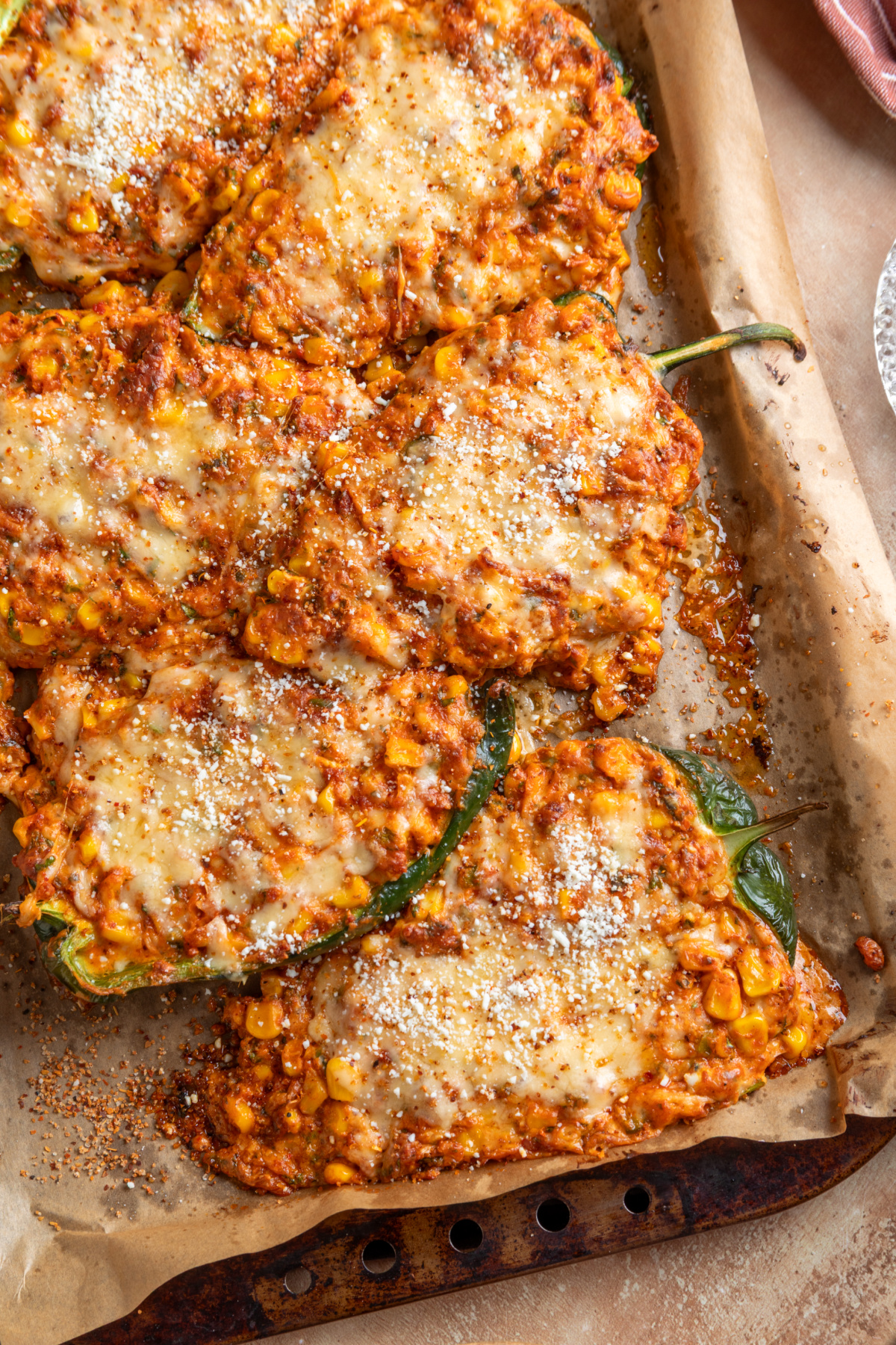Baked Mexican street corn stuffed poblano peppers filled with chorizo and corn and topped with melted cheese, Cotija and Taj&iacute;n
