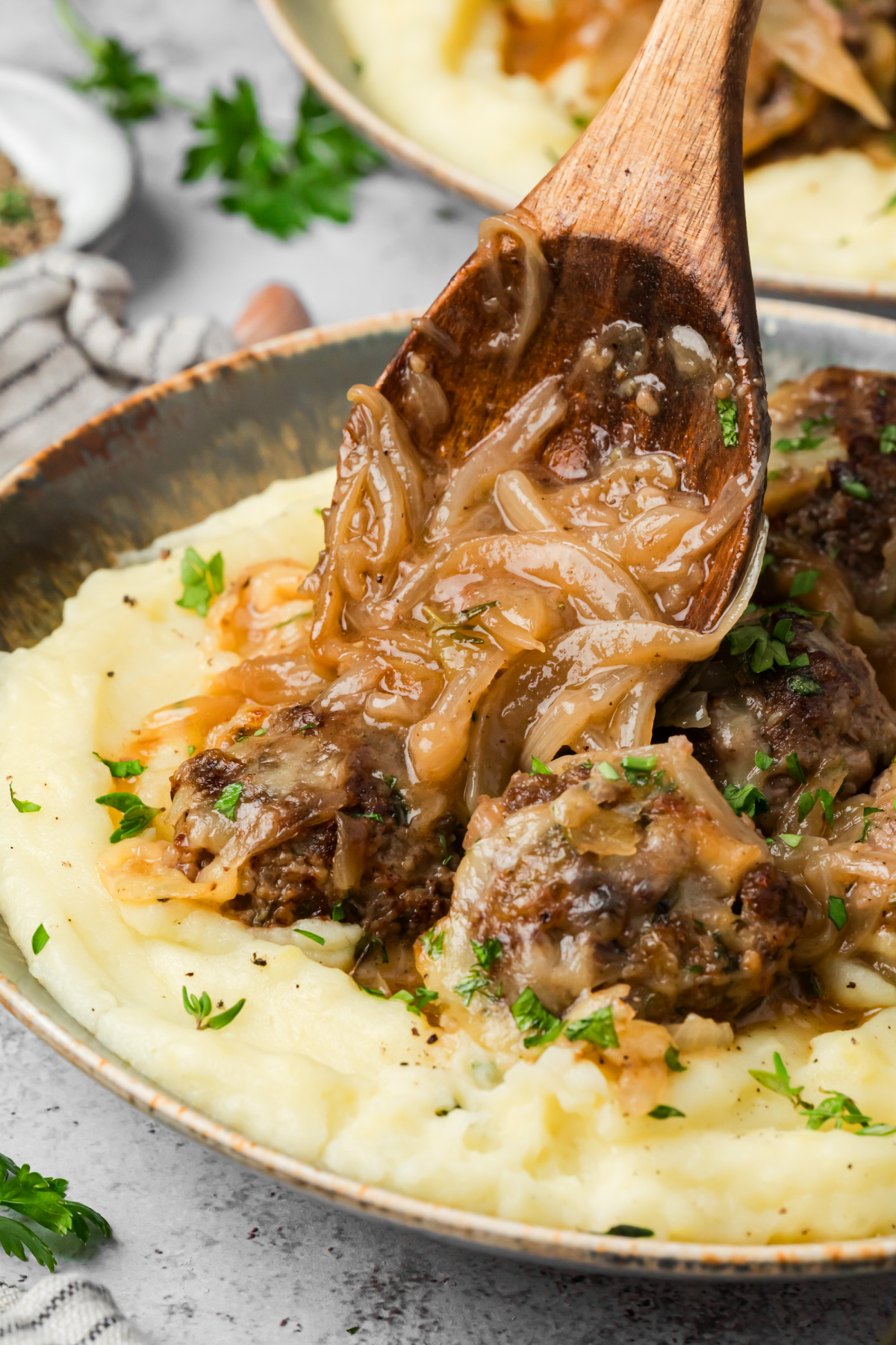 Caramelized onion sauce spooned over Gruyère-topped beef meatballs and mashed potatoes. Caramelized onion sauce spooned over beef meatballs with Gruyère and mashed potatoes