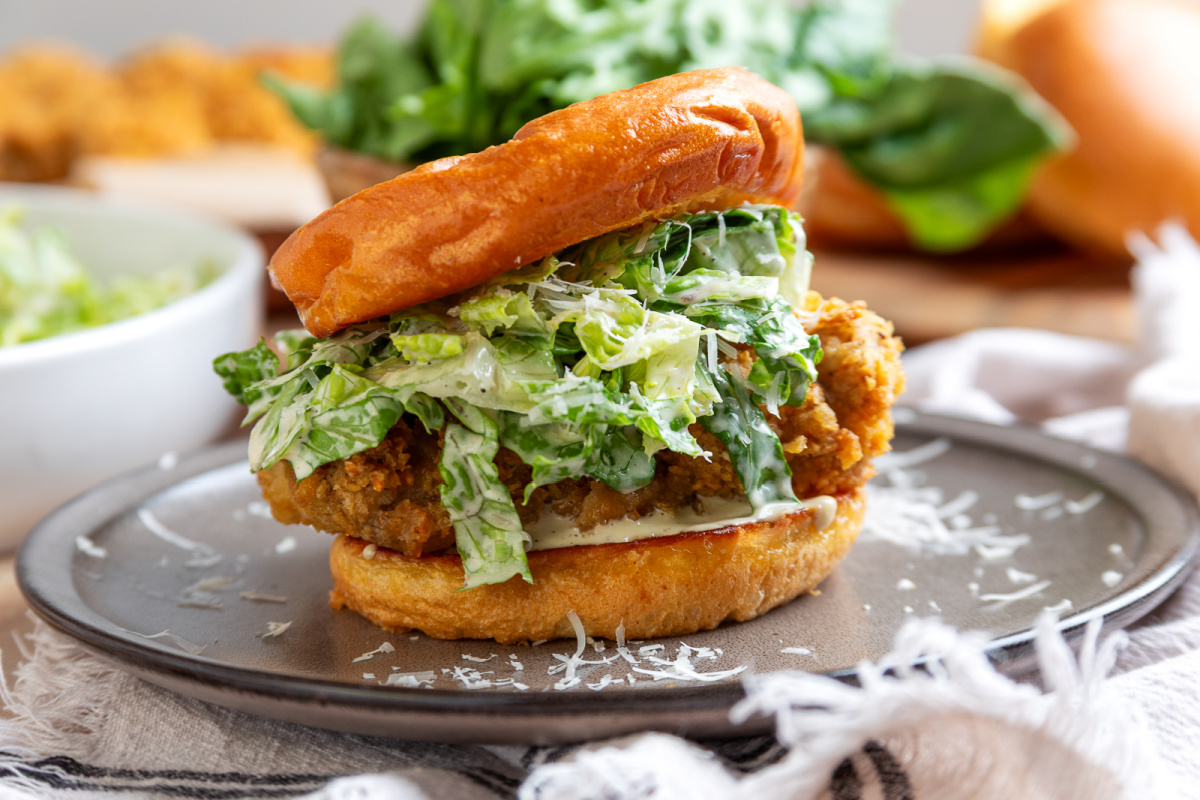 Air fryer chicken Caesar salad sandwich Chicken Caesar salad sandwich with crispy potato chip-crusted chicken cooked in the air fryer, homemade Caesar salad, and Parmesan cheese on a toasted bun.